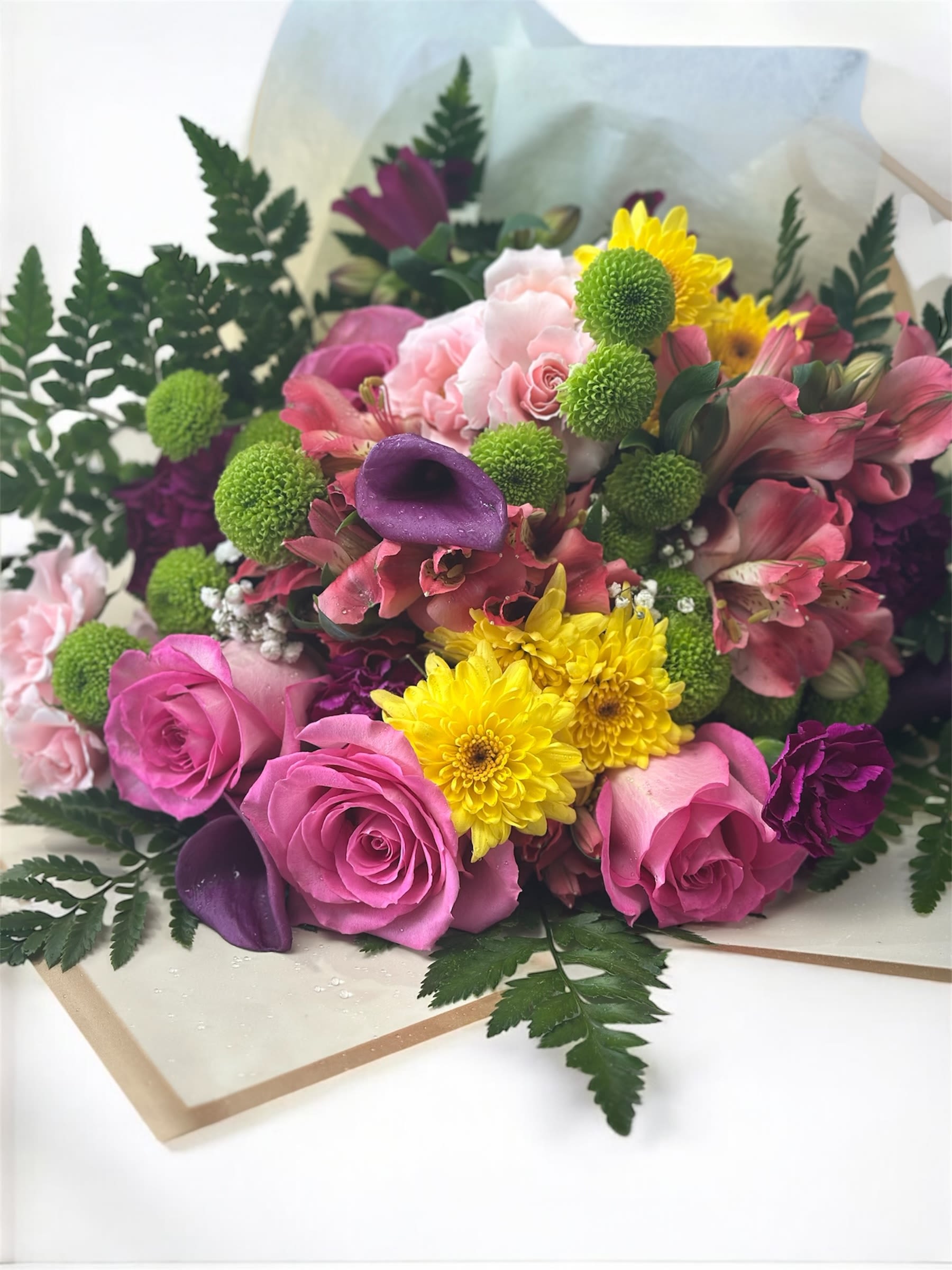 Bouquet of pink roses, yellow chrysanthemums, and purple calla lilies