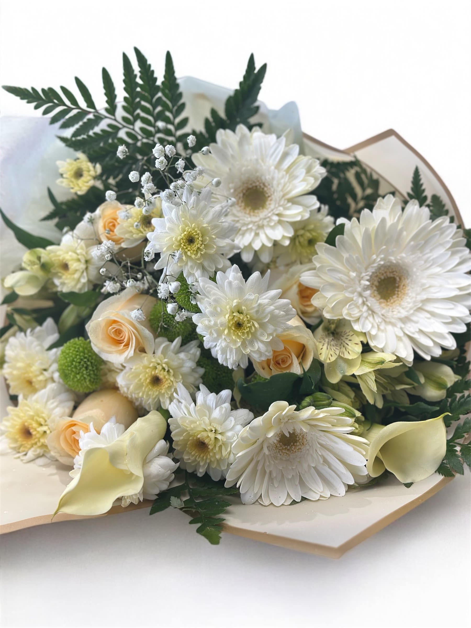 Bouquet of white daisies, pale roses, and calla lilies