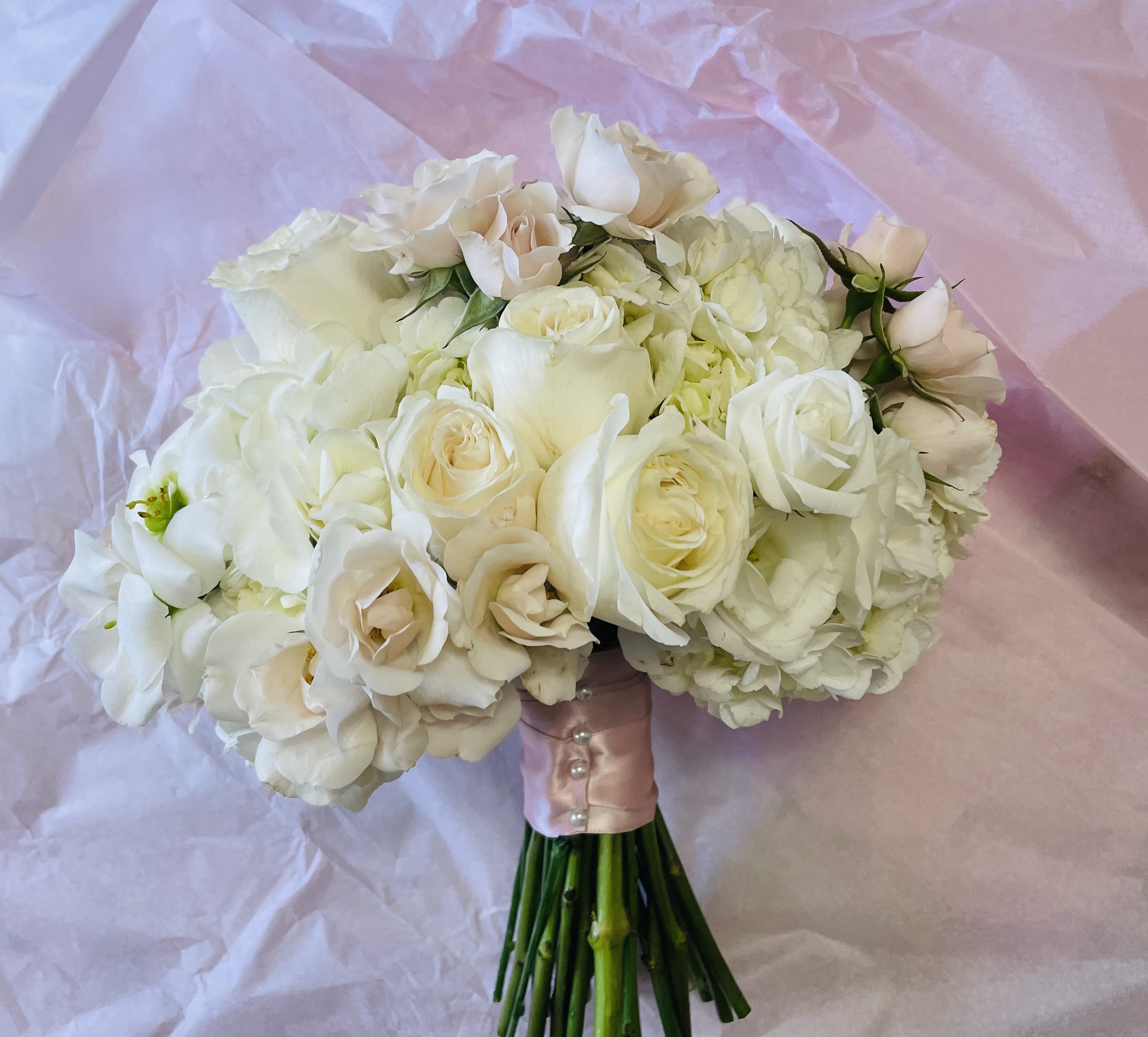 White rose and hydrangea bouquet wrapped in pink paper