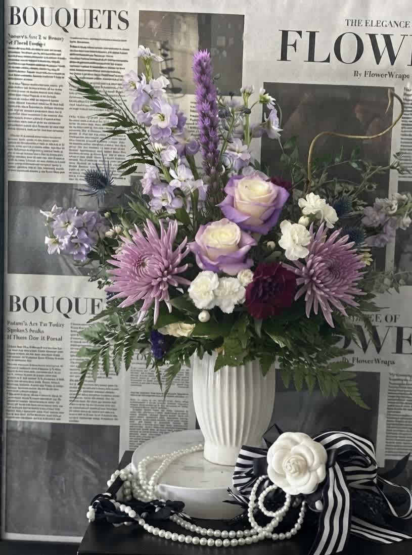 Lavender and white bouquet in a white vase with ribbon and pearl accents