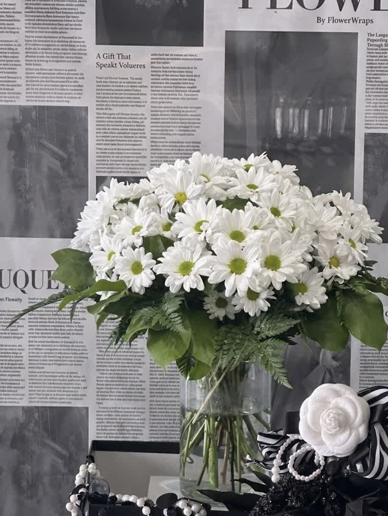 White daisy bouquet in a clear glass vase with green centers