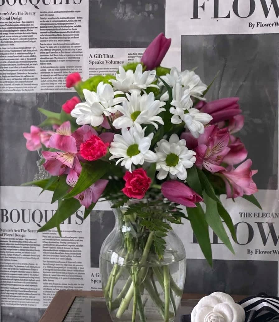 Bouquet of white daisies and pink flowers in a clear glass vase
