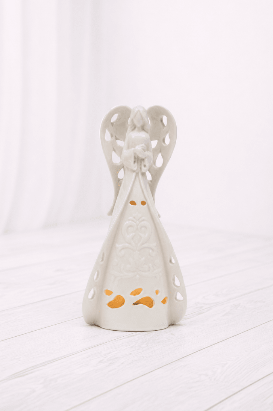 Porcelain Lighted Angel - A peaceful white ceramic angel luminary with delicate cutout details and a soft glow. A thoughtful sympathy gift or memorial keepsake for honoring someone special. 2 sizes available, comes with a bow.