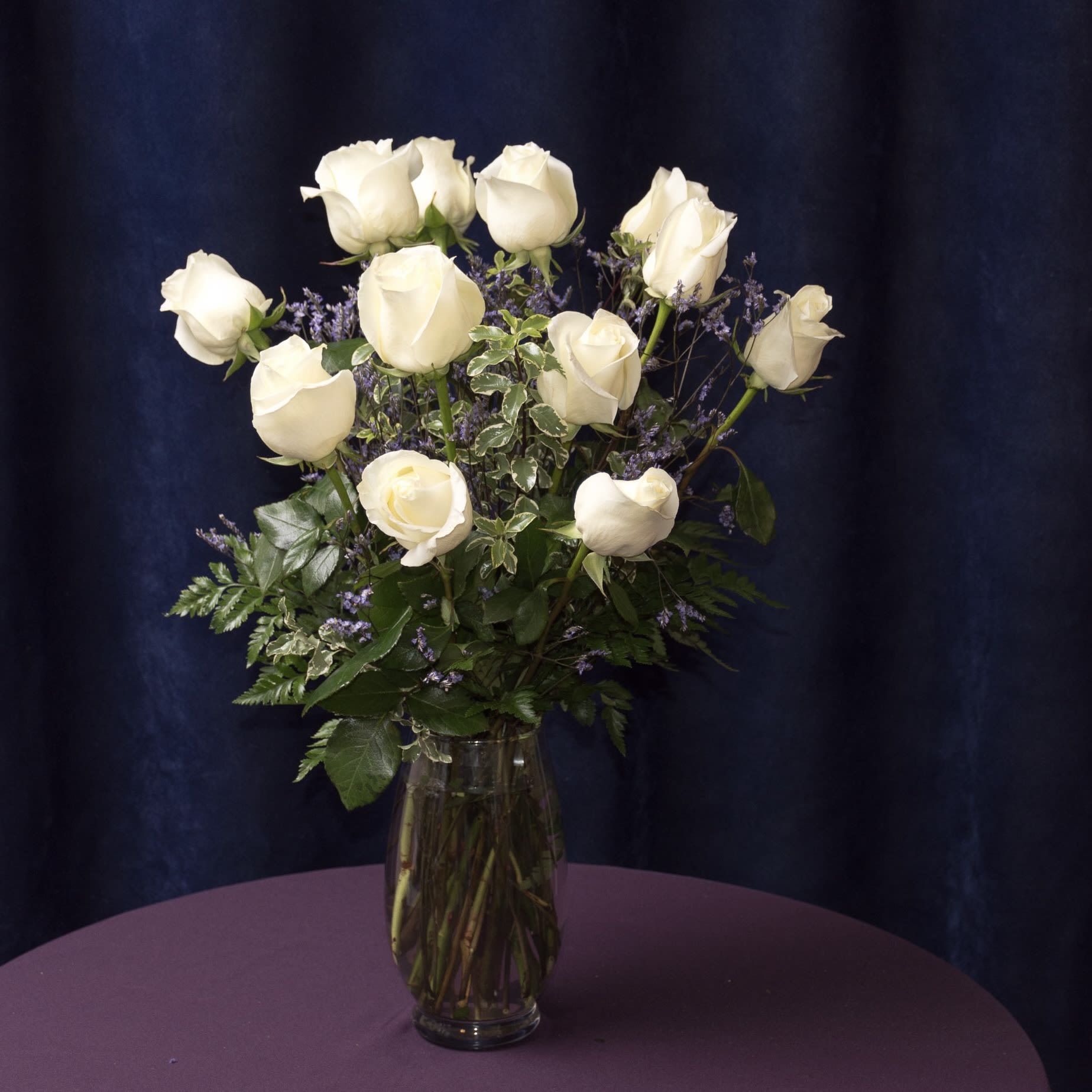 Elegant Roses in White - A dozen white roses, with trendy greenery in a clear glass vase.  