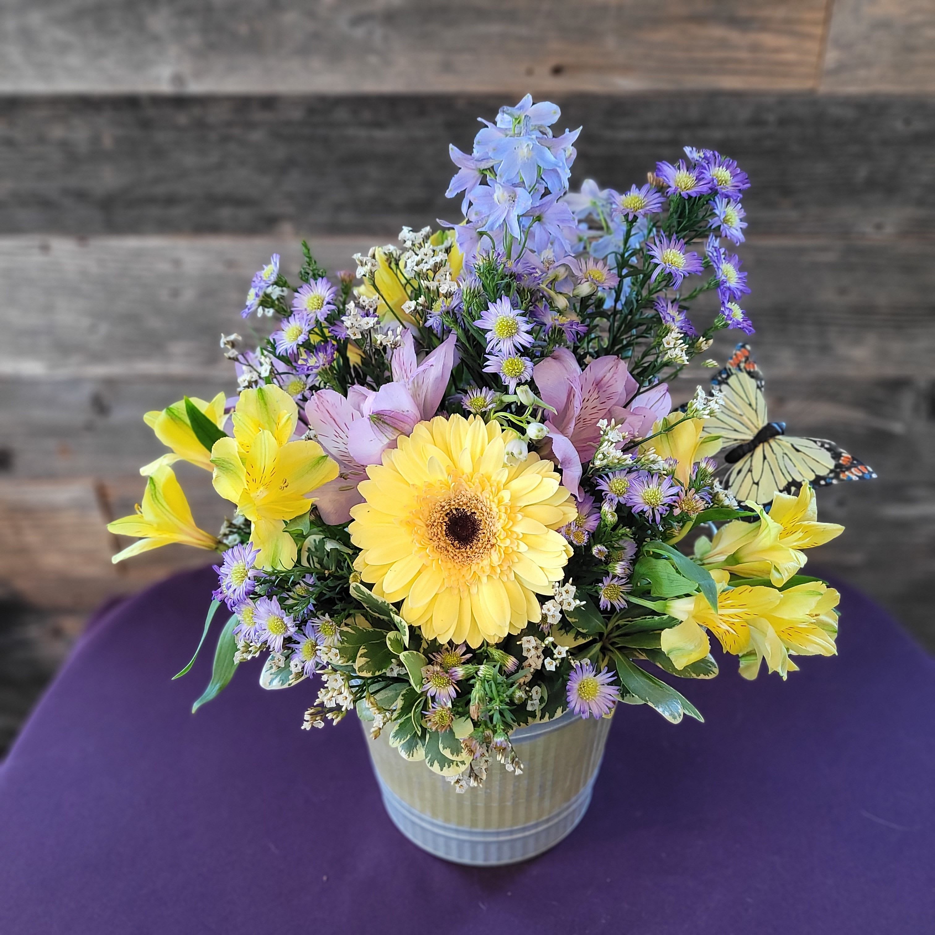 Butterfly Meadow - Soft, luminous shades of yellow, lavender, blush, and pale blue come together in a garden-inspired design with a graceful butterfly accent. Fresh and elegant without feeling formal, this arrangement is a lovely choice for thoughtful gifting, spring or summer occasions, get-well sentiments, or simply brightening someone’s home in a beautiful way.