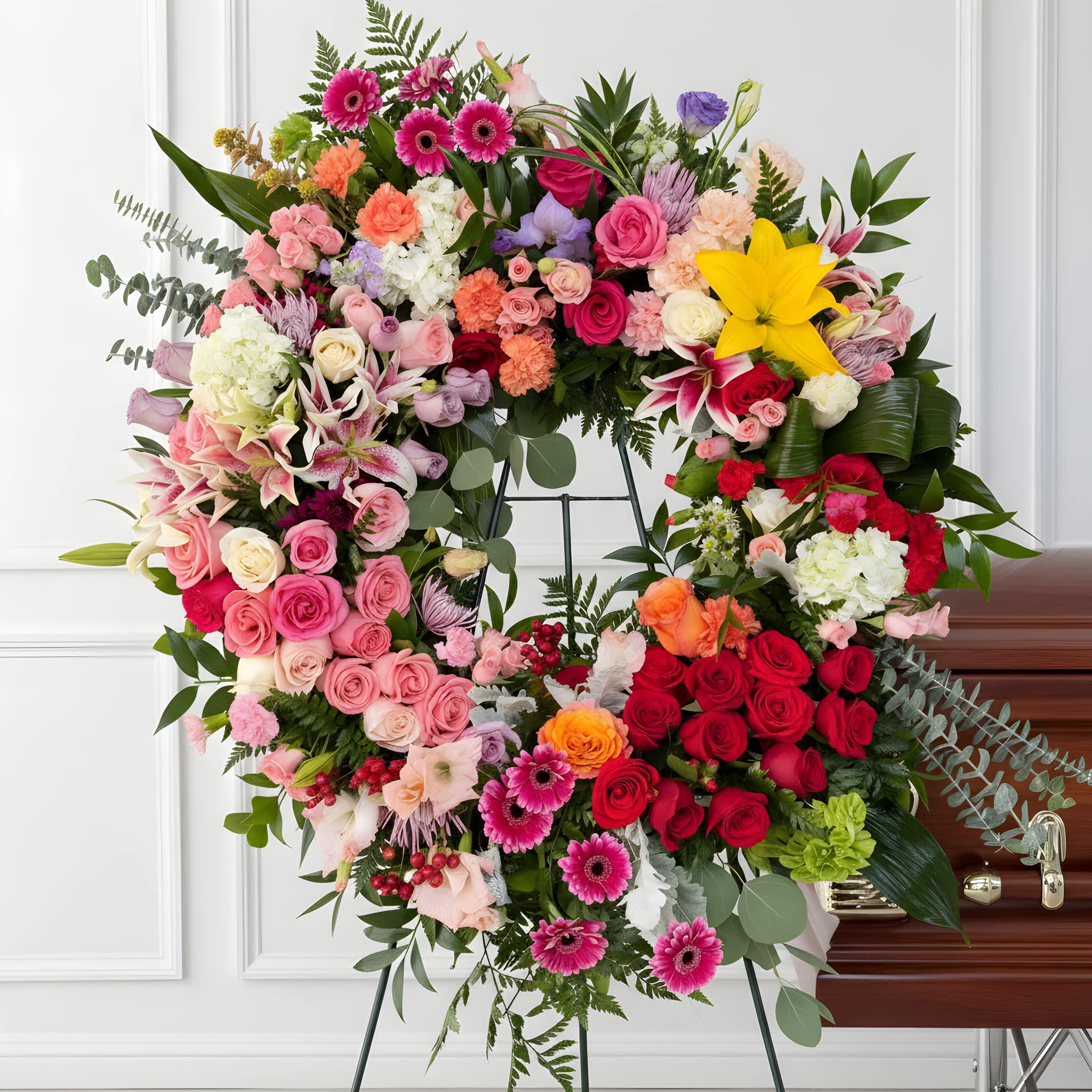 Large heart-shaped floral wreath with roses, lilies, and gerbera daisies