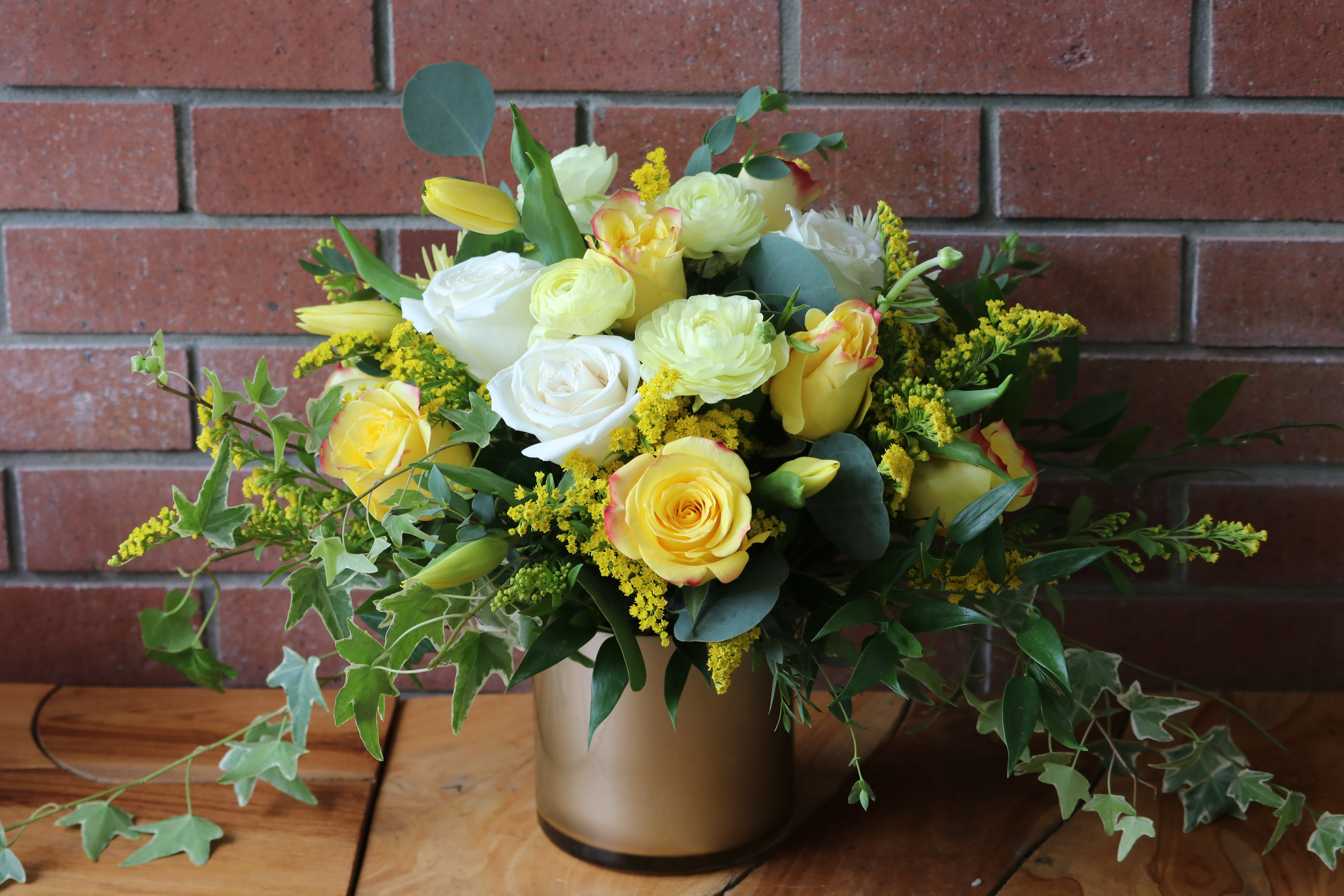 Yellow and white rose bouquet in a gold vase