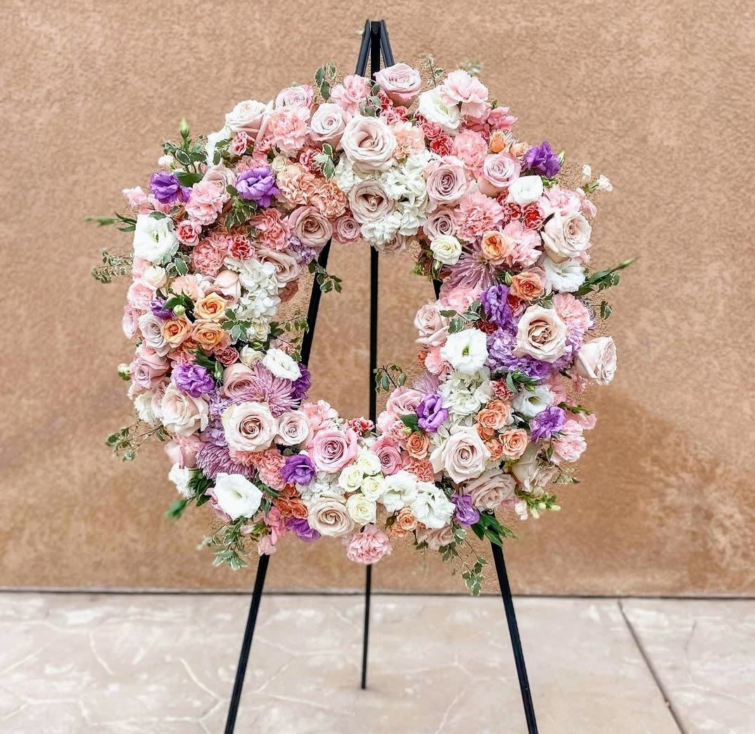 Pastel floral wreath on a black stand