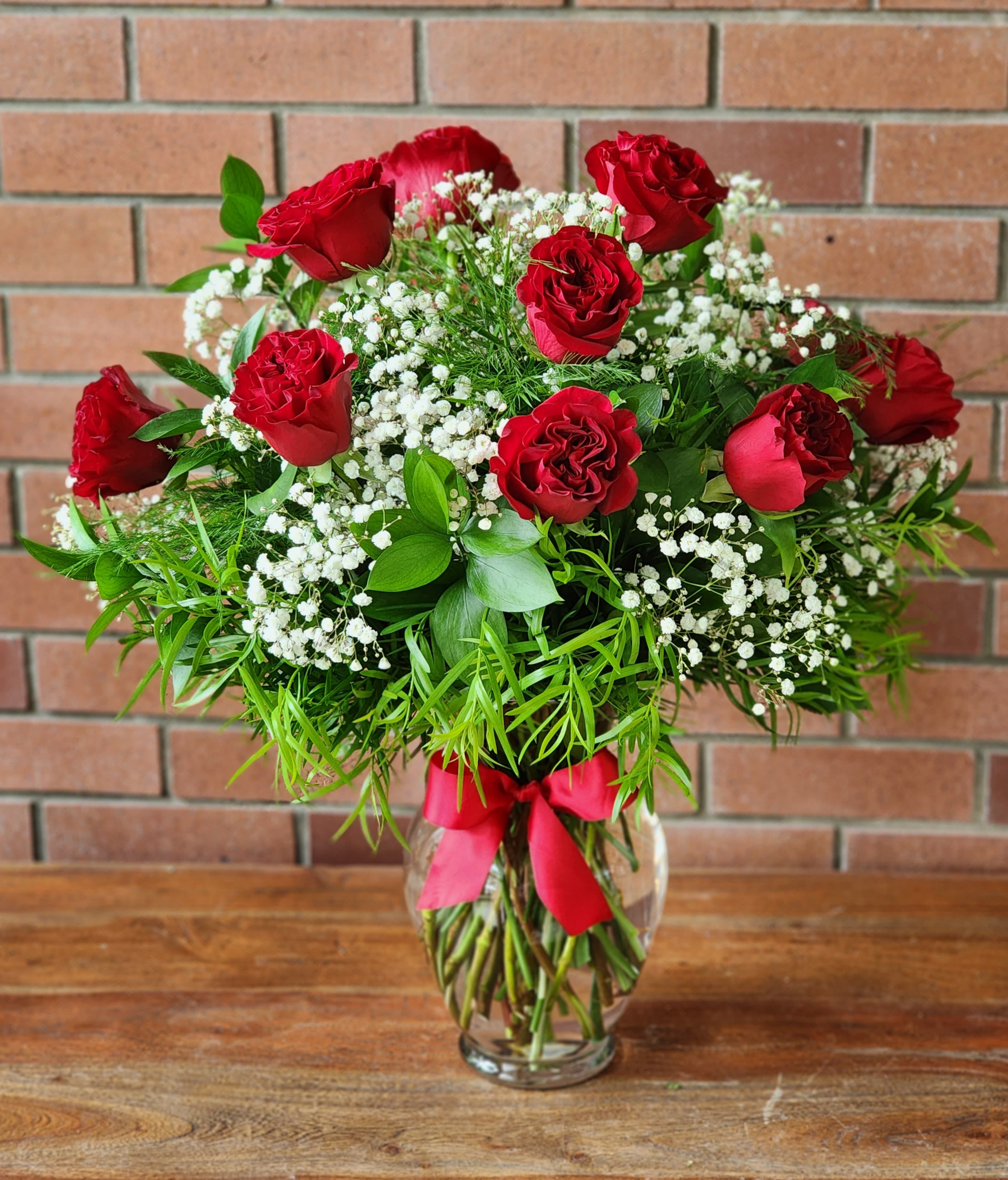Red roses in a glass vase with white baby's breath