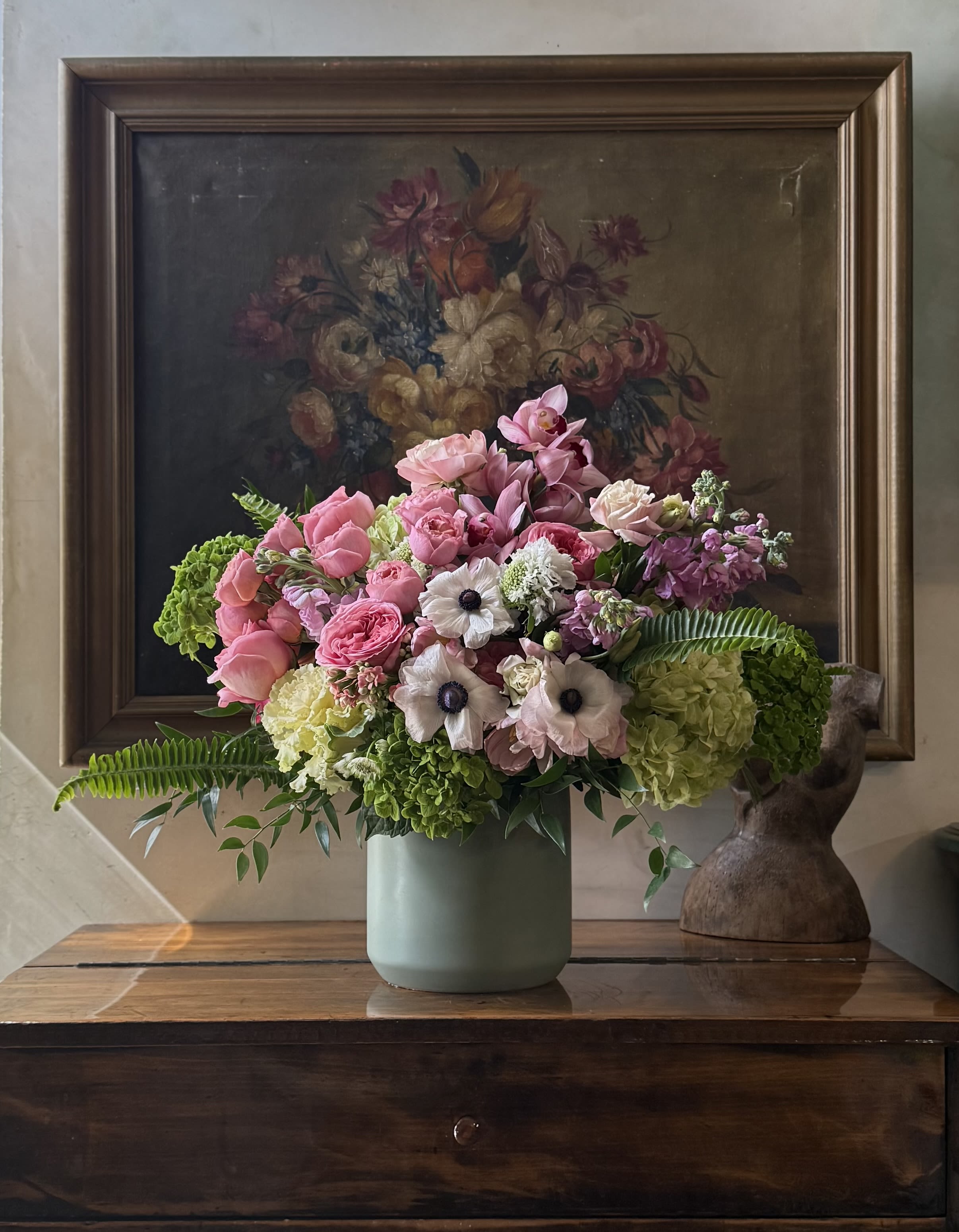 Pink and white mixed flower arrangement in a pale green vase