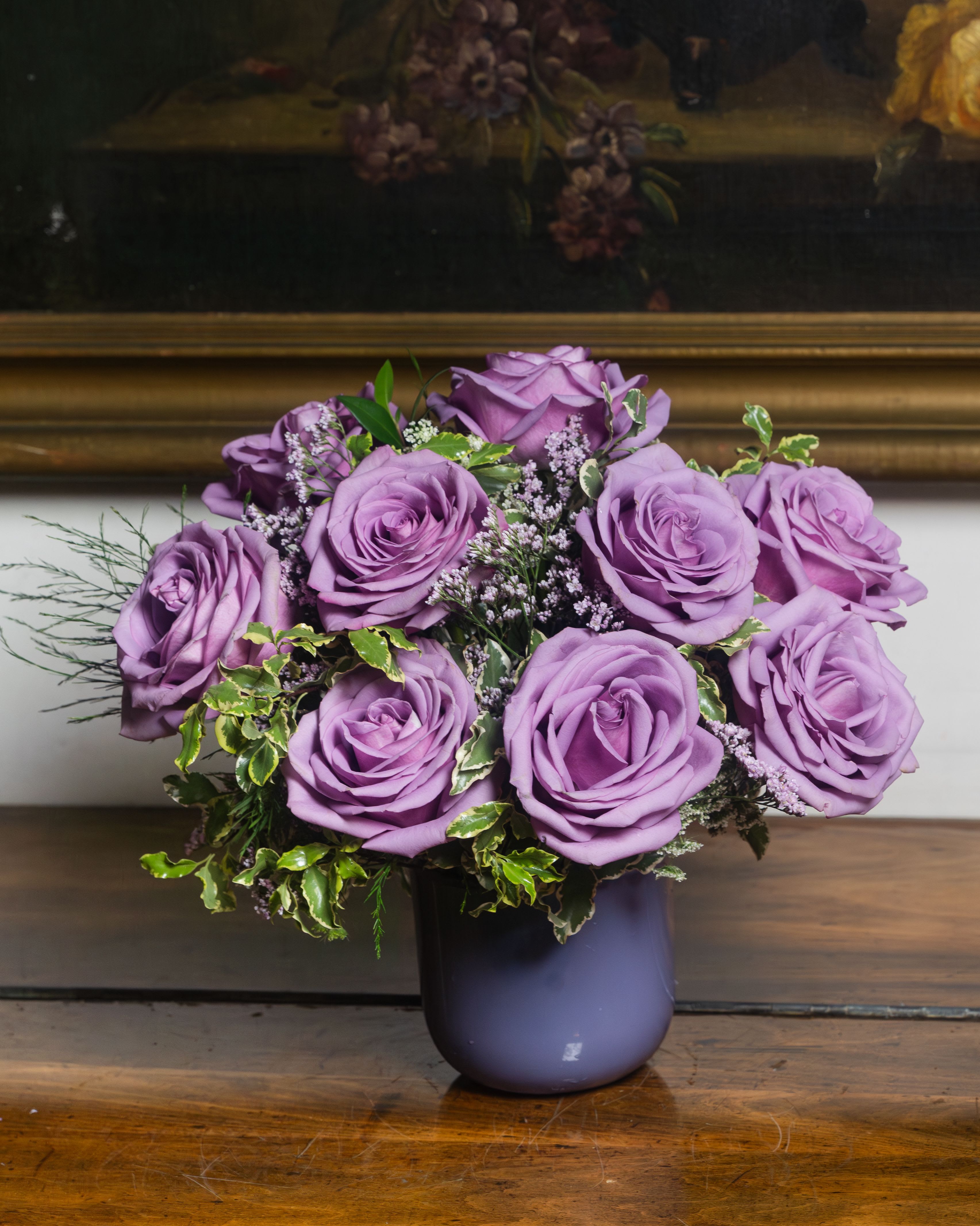 The Lilac Edit - Our signature lavender rose arrangement — a study in softness and sophistication. Premium lavender roses in a dreamy violet ceramic vase, accented with delicate limonium and lush variegated greenery. Whether you choose a classic dozen or an abundant two dozen, every version is designed to feel like a moment frozen in time. Available in Standard, Deluxe, and Premium — because she deserves exactly as much as you want to give.