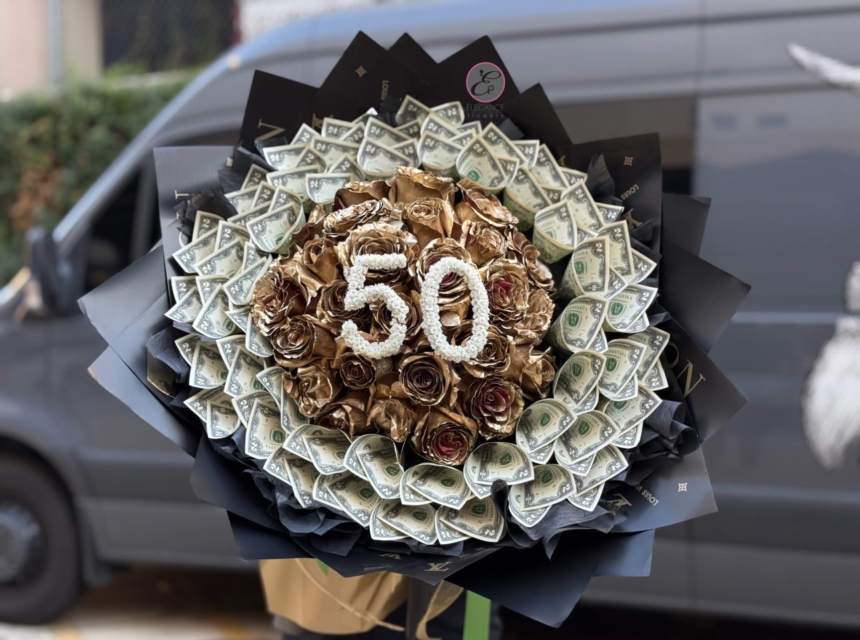 Bouquet of gold roses and dollar bills with a "50" topper