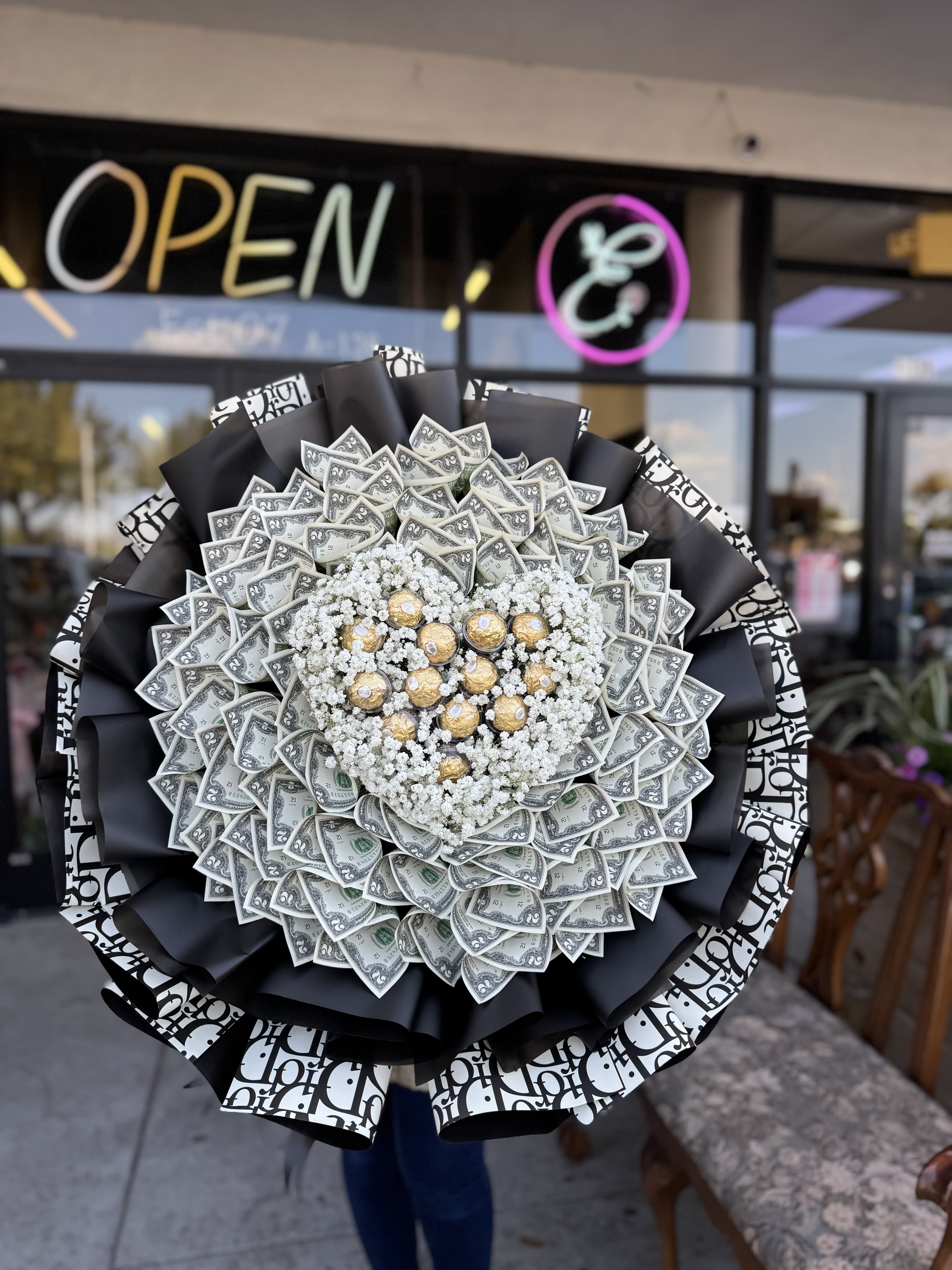 Large bouquet made of dollar bills with white filler flowers and gold chocolates