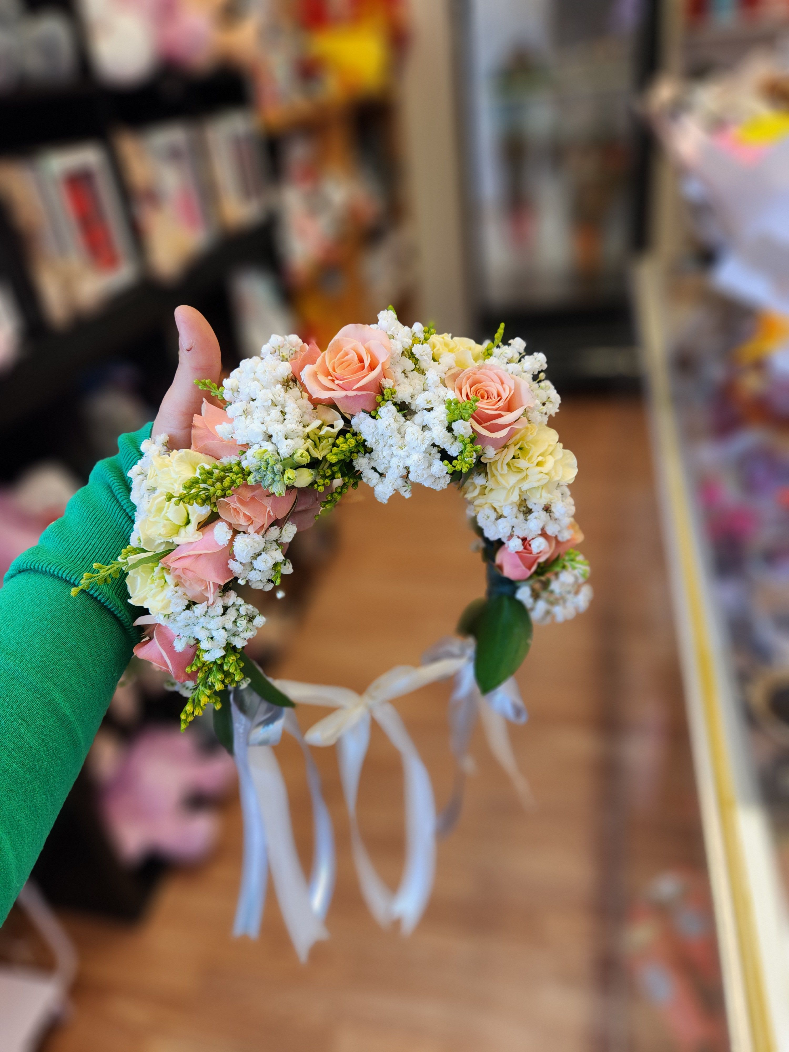 Floral crown with pink roses and white filler flowers tied with ribbons