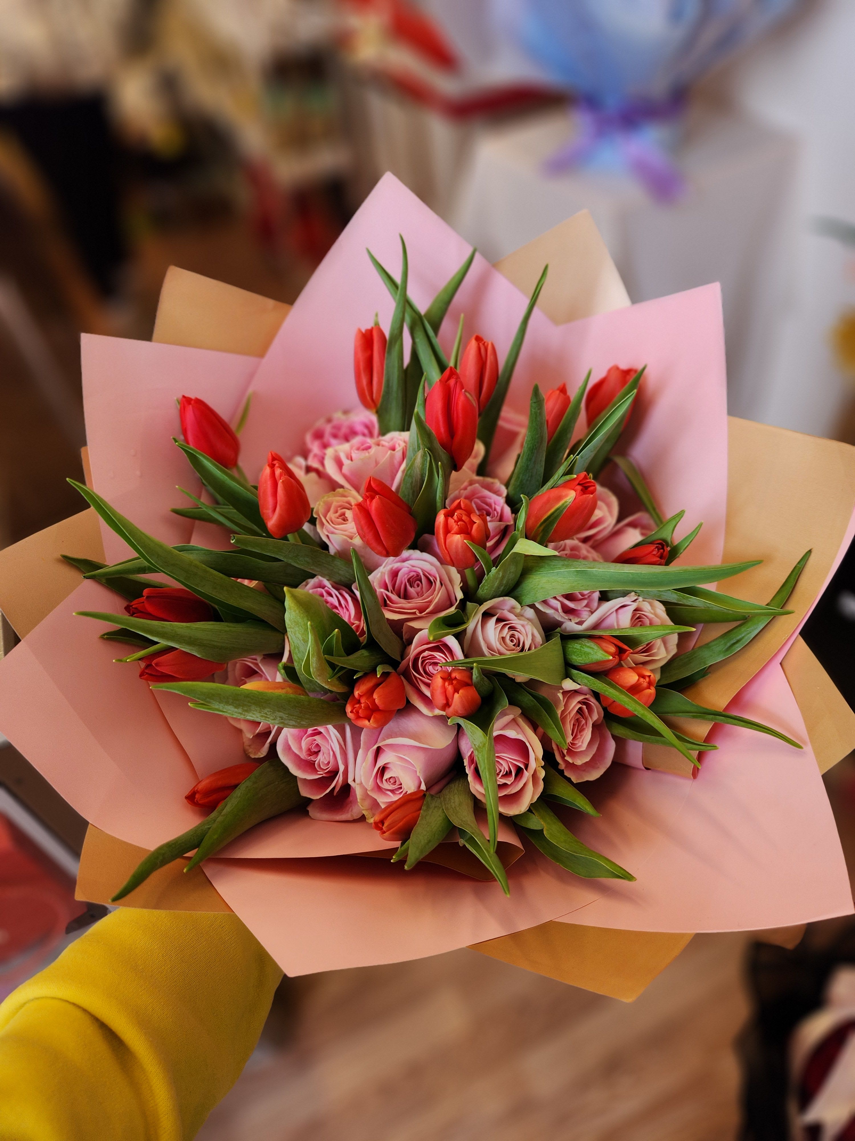 Pink roses and red tulips wrapped in pastel paper