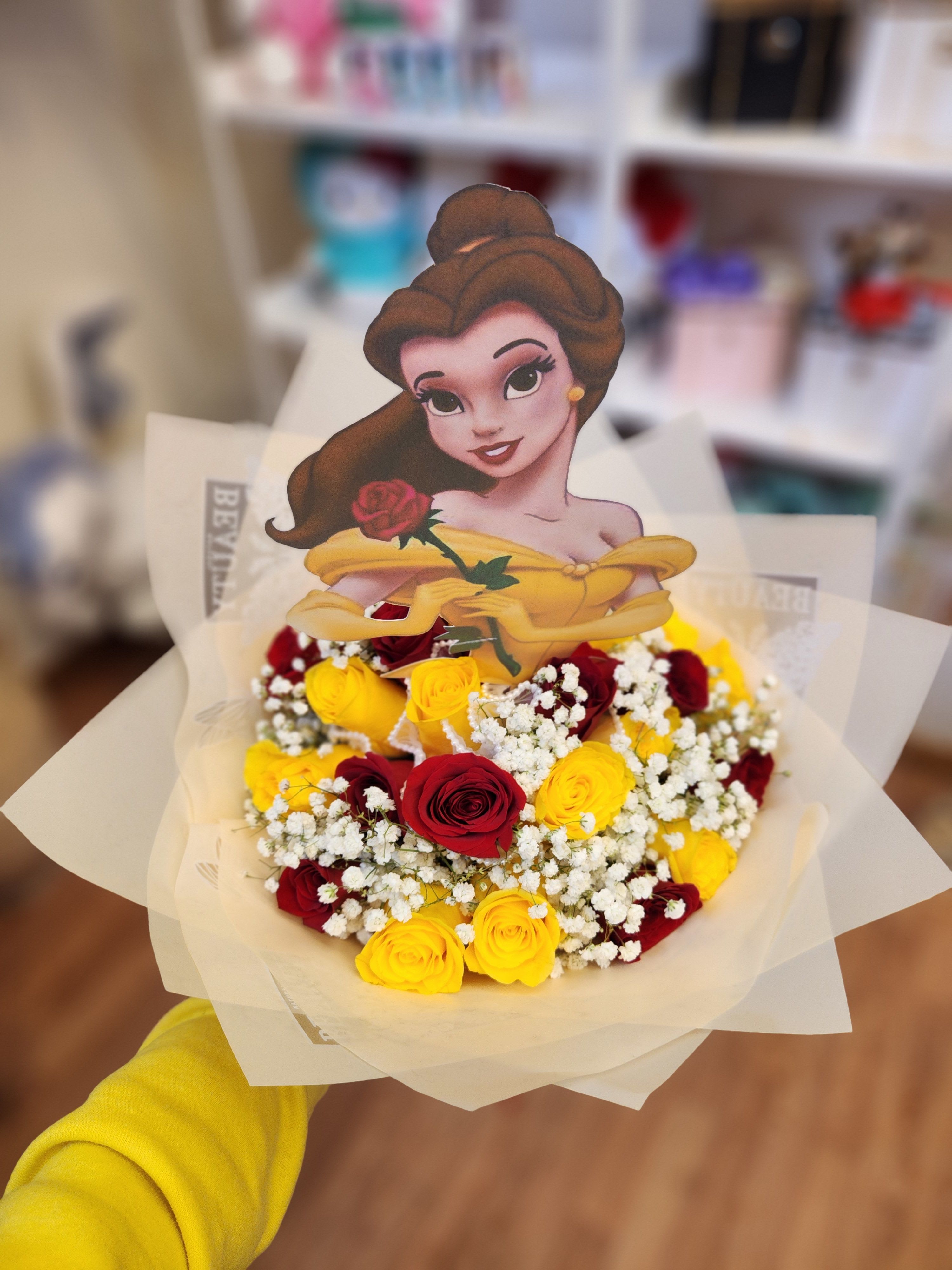 Bouquet of red and yellow roses with a princess topper