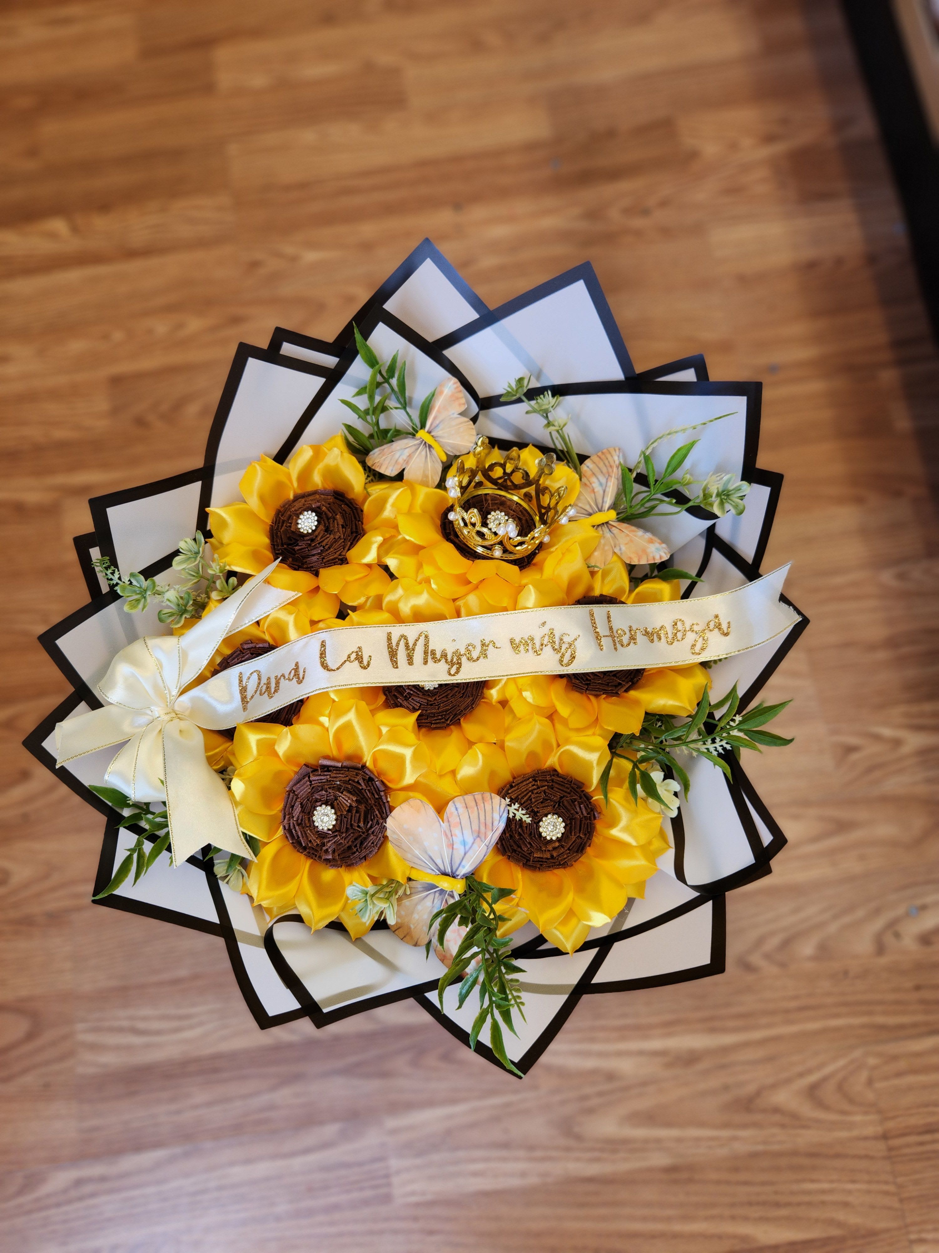 Yellow flower bouquet with butterflies and a ribbon on a wooden floor