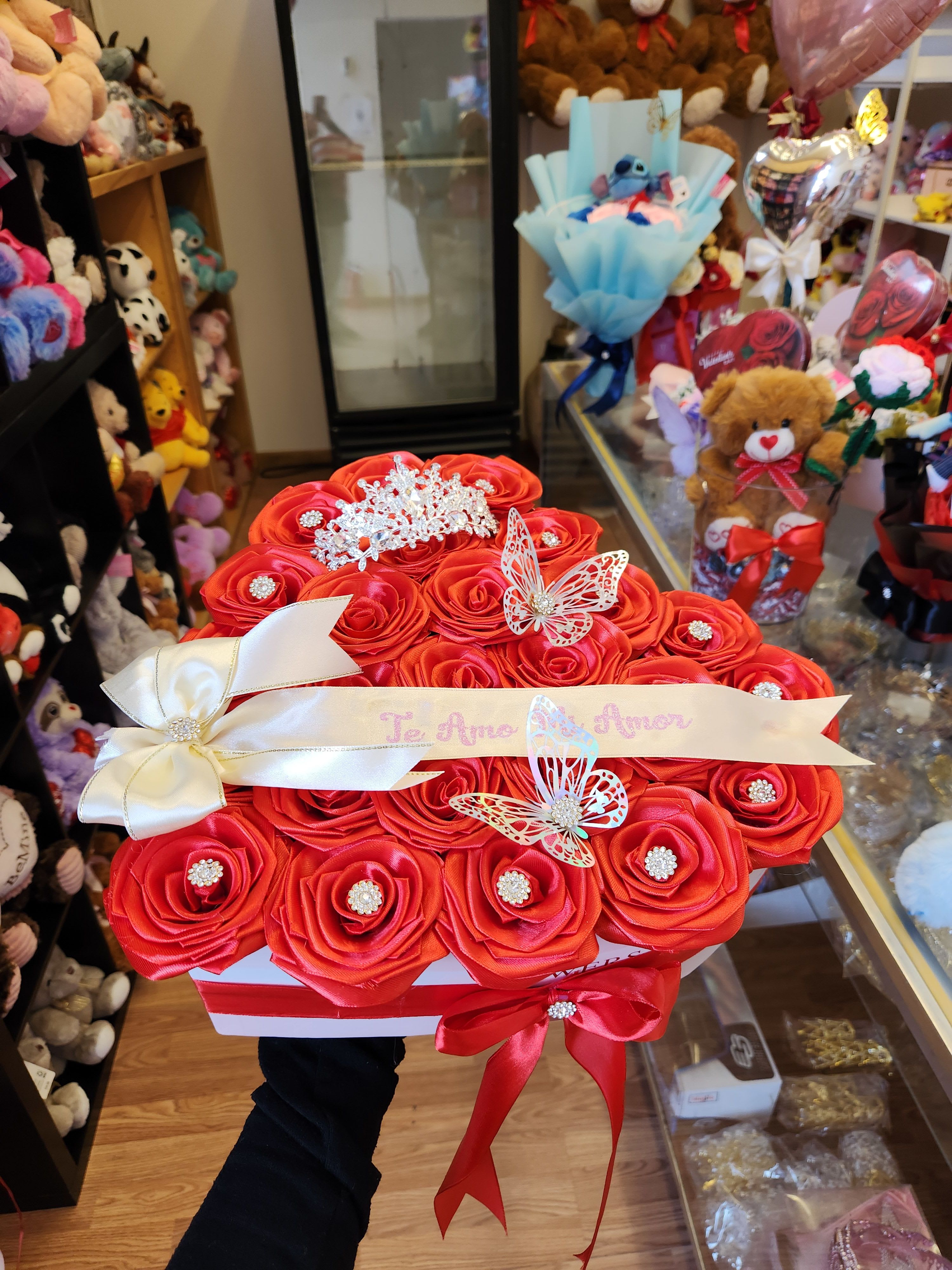 Red rose bouquet in a white box with ribbon and butterfly decorations