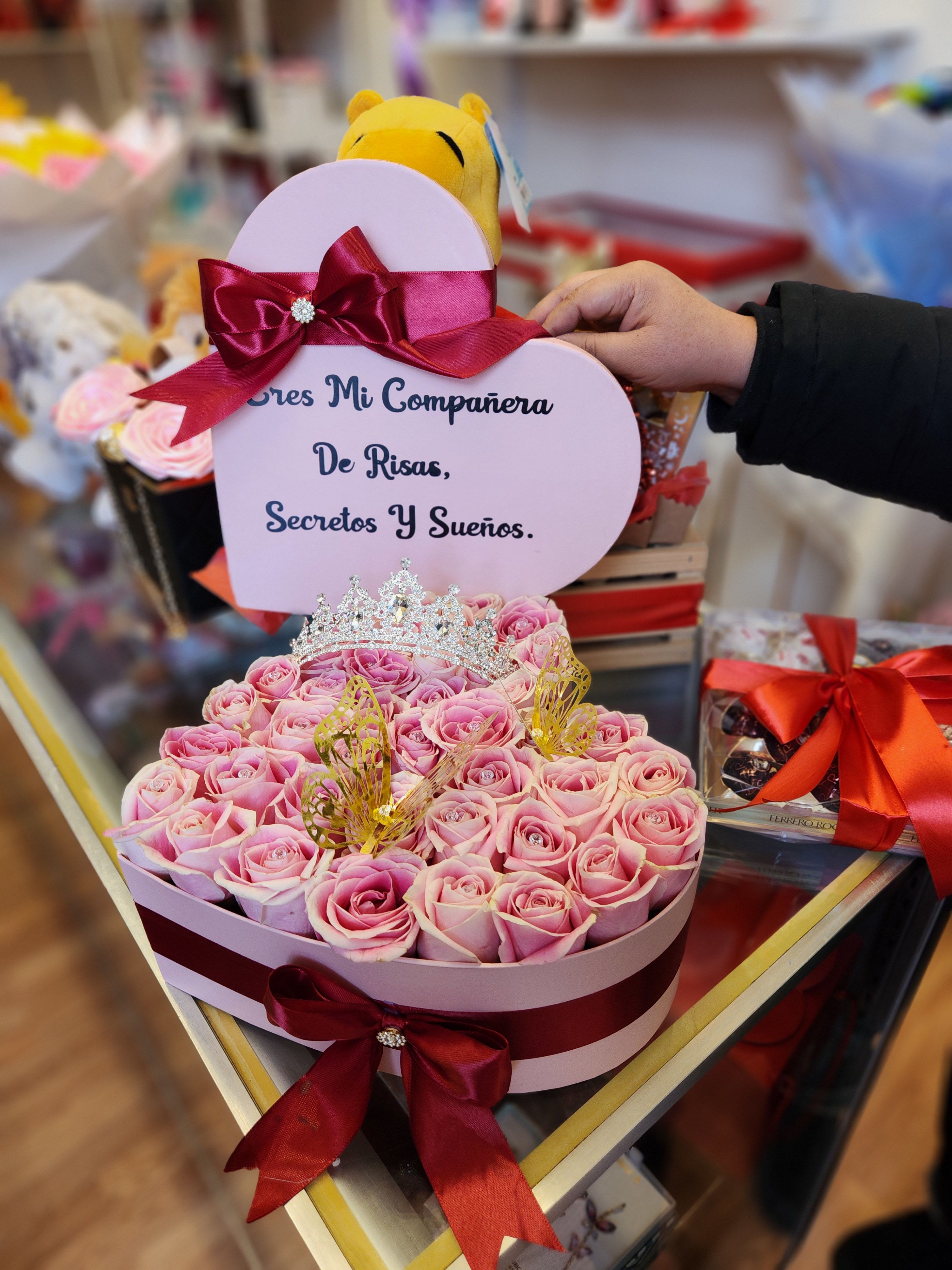 Heart-shaped box of pink roses with a tiara and ribbon bow