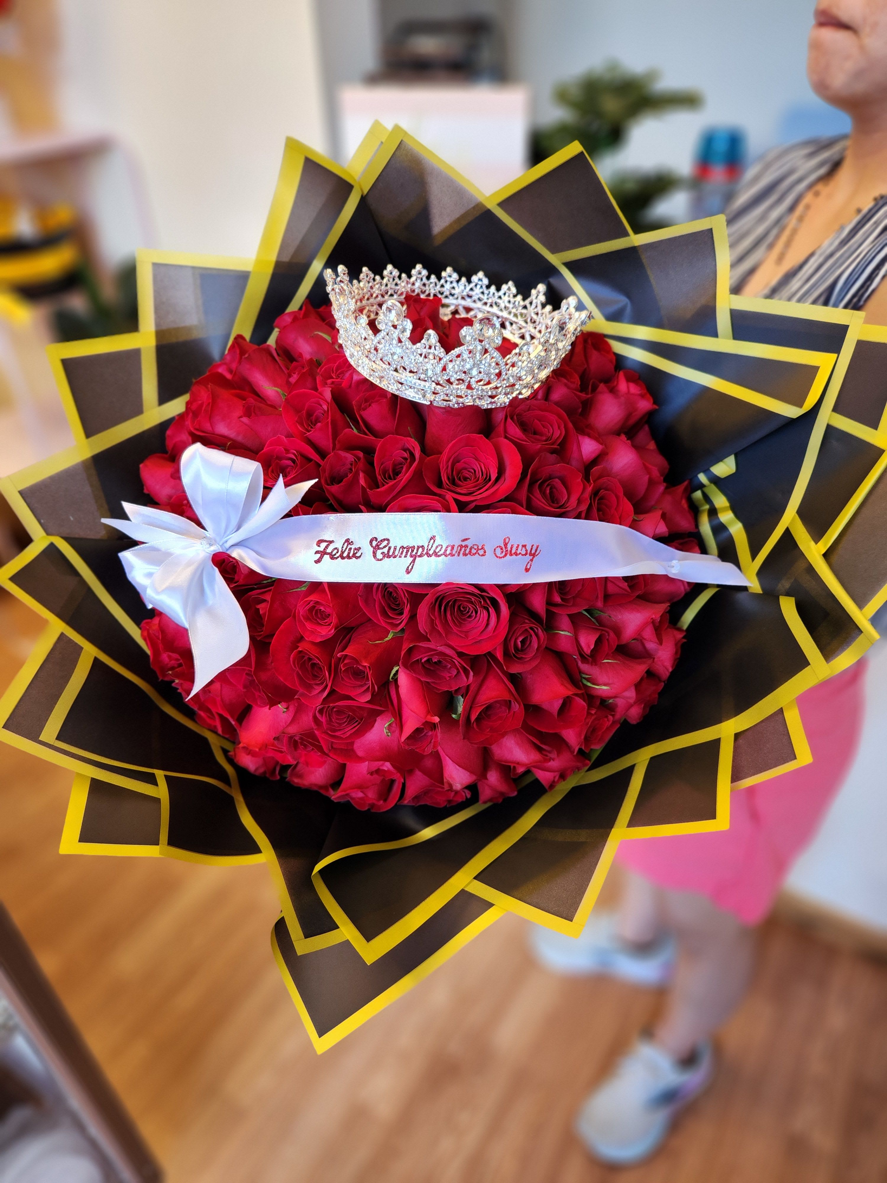 Bouquet of red roses with a silver crown and white ribbon