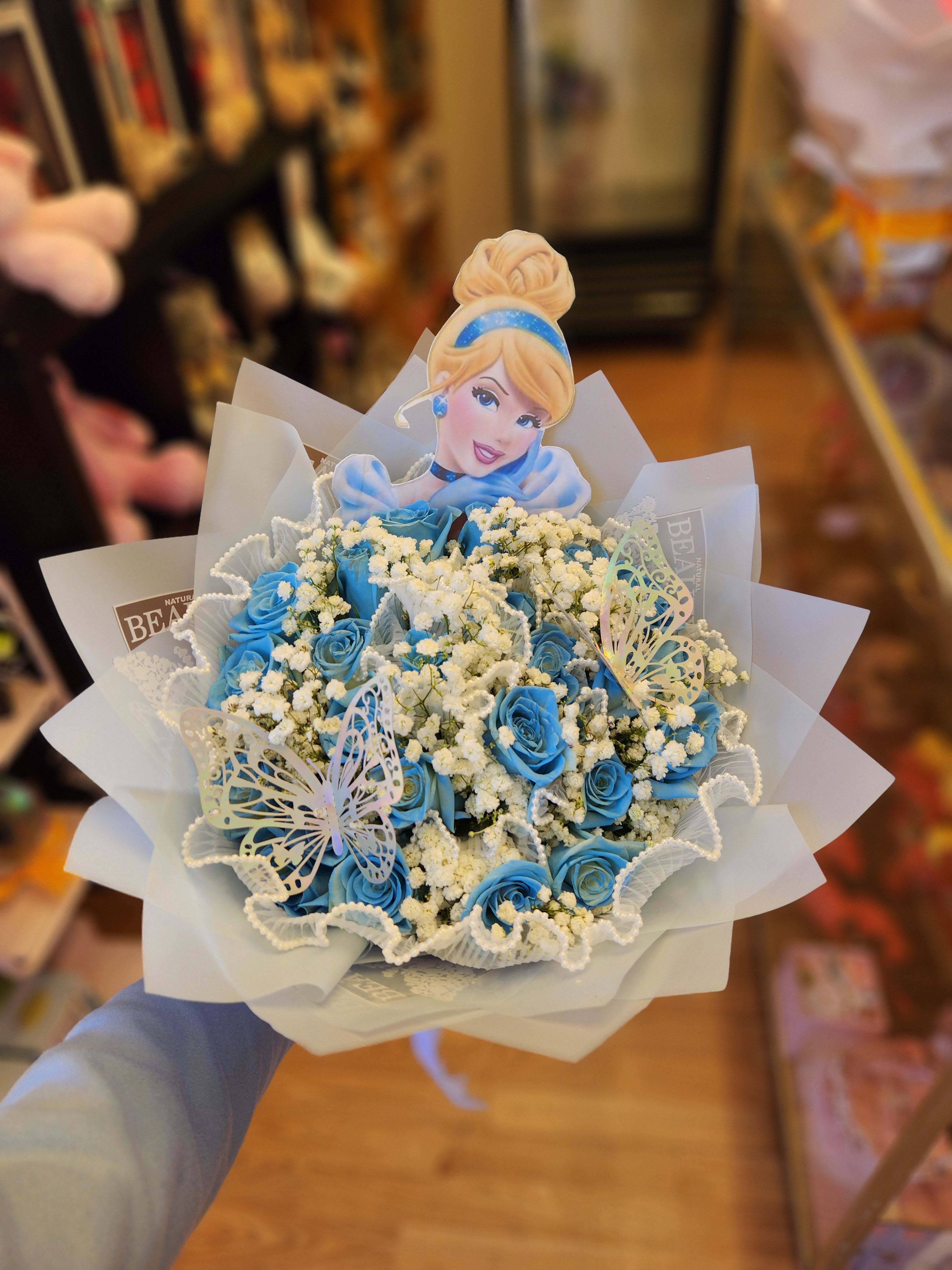 Blue rose bouquet with baby’s breath and a Cinderella topper