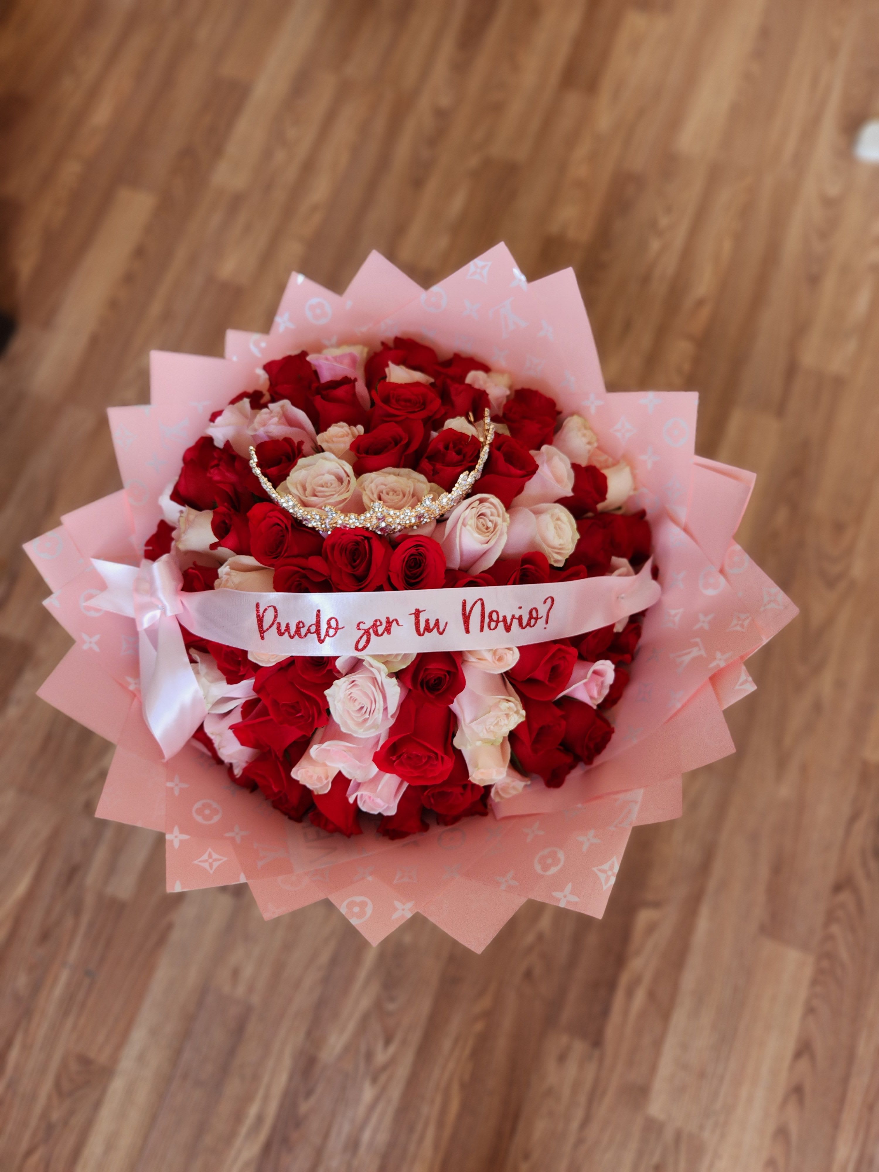 Bouquet of red and blush roses with a pink ribbon and tiara