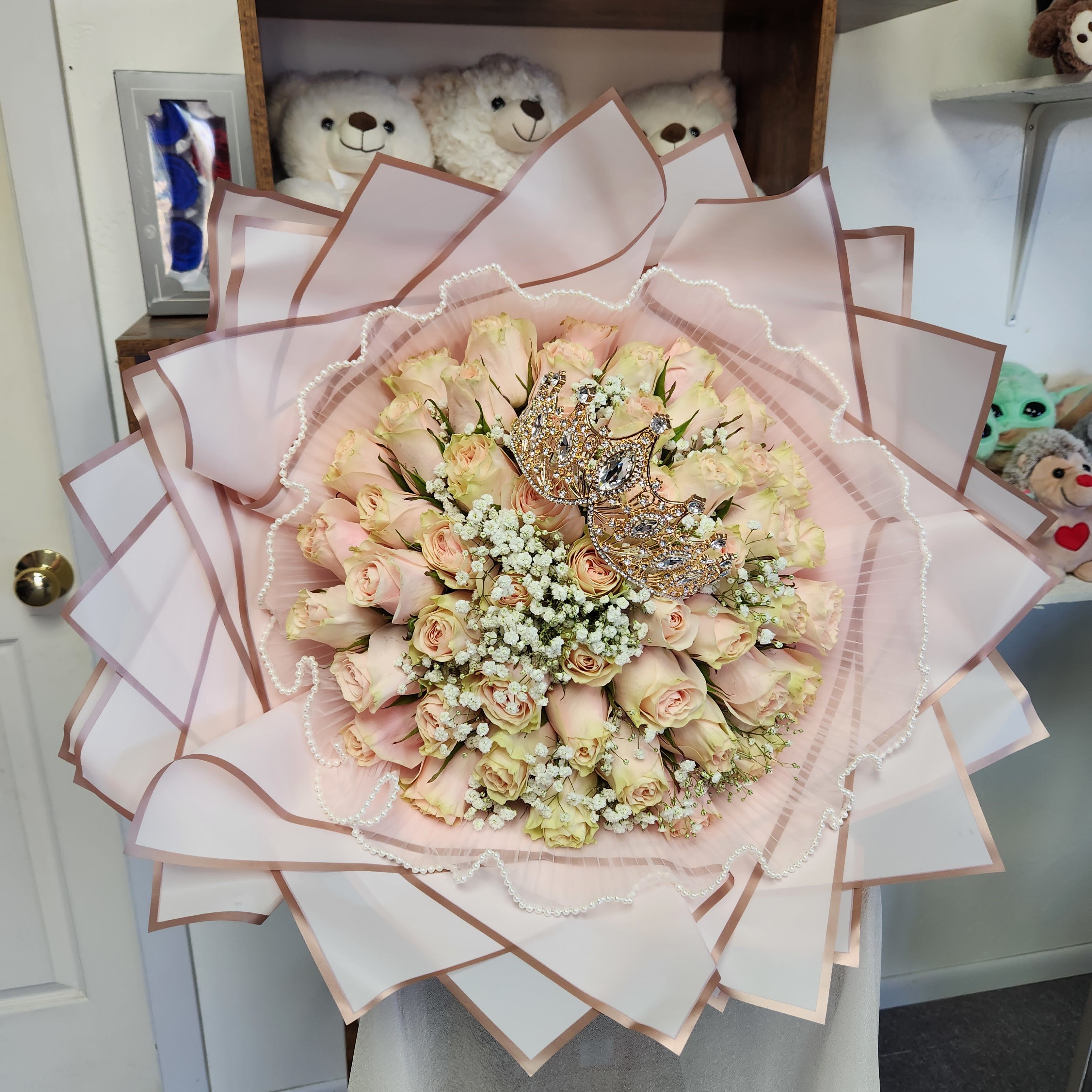 Bouquet of pale pink roses with pearl accents and decorative crowns