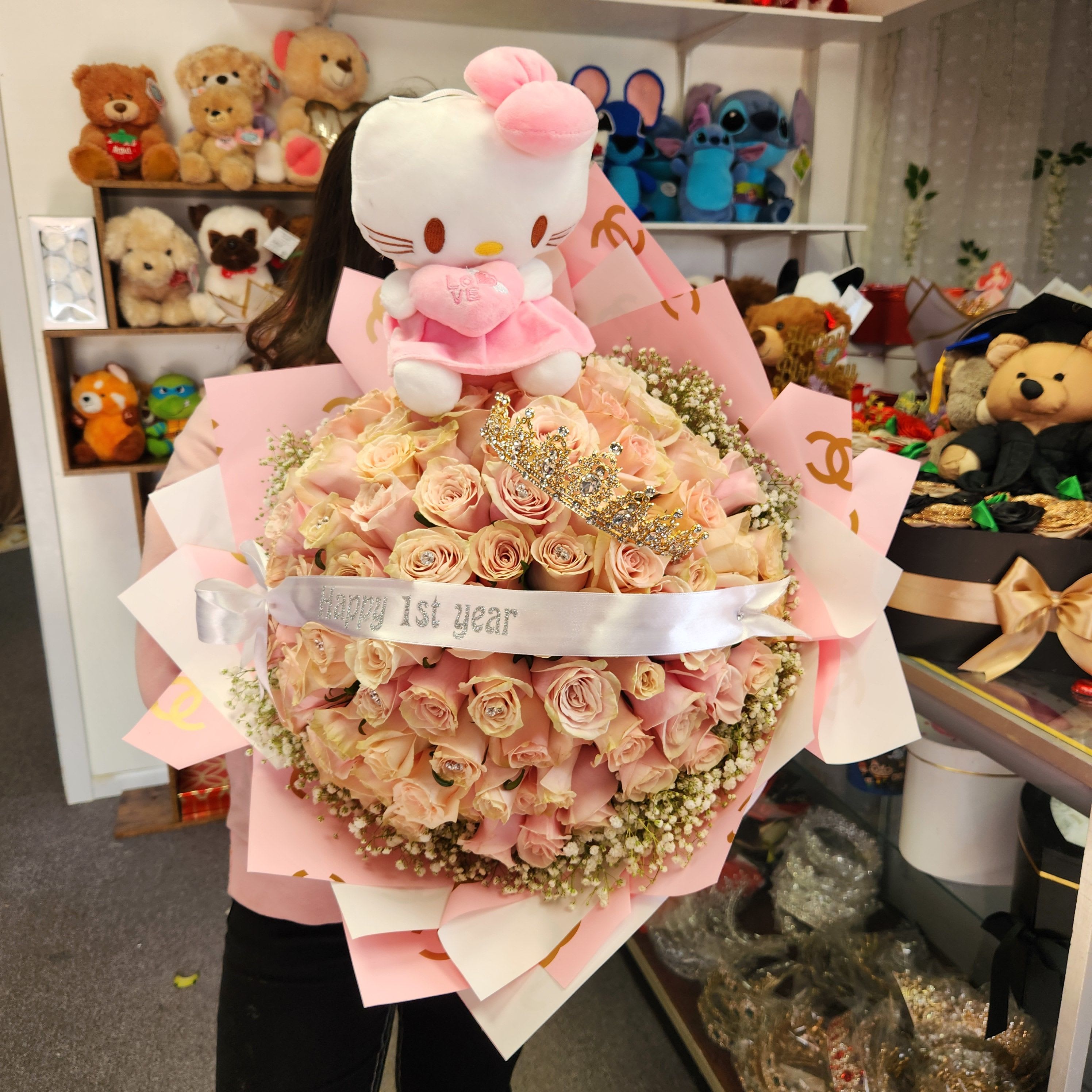Pink rose bouquet topped with a Hello Kitty plush and ribbon