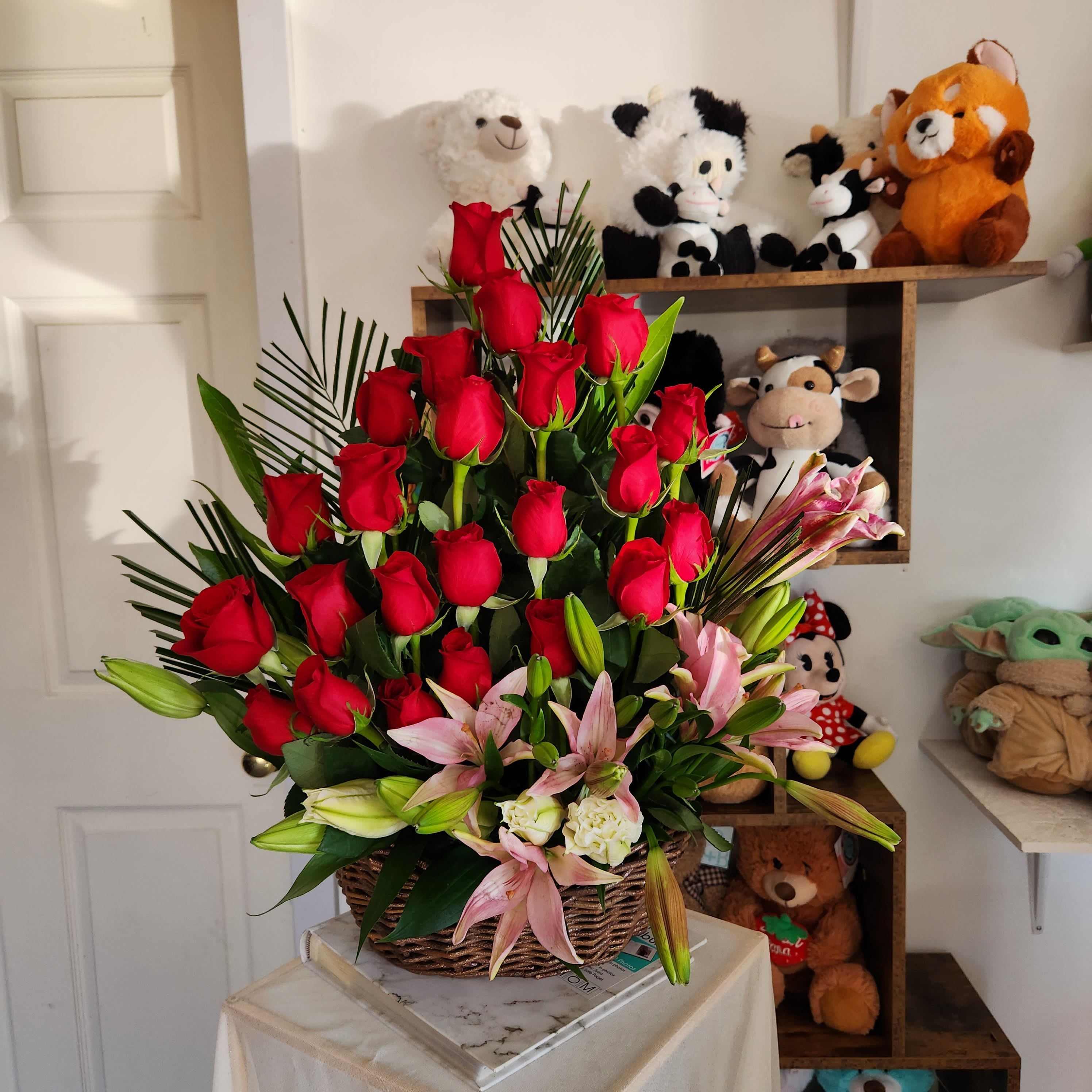Basket arrangement of red roses and pink lilies