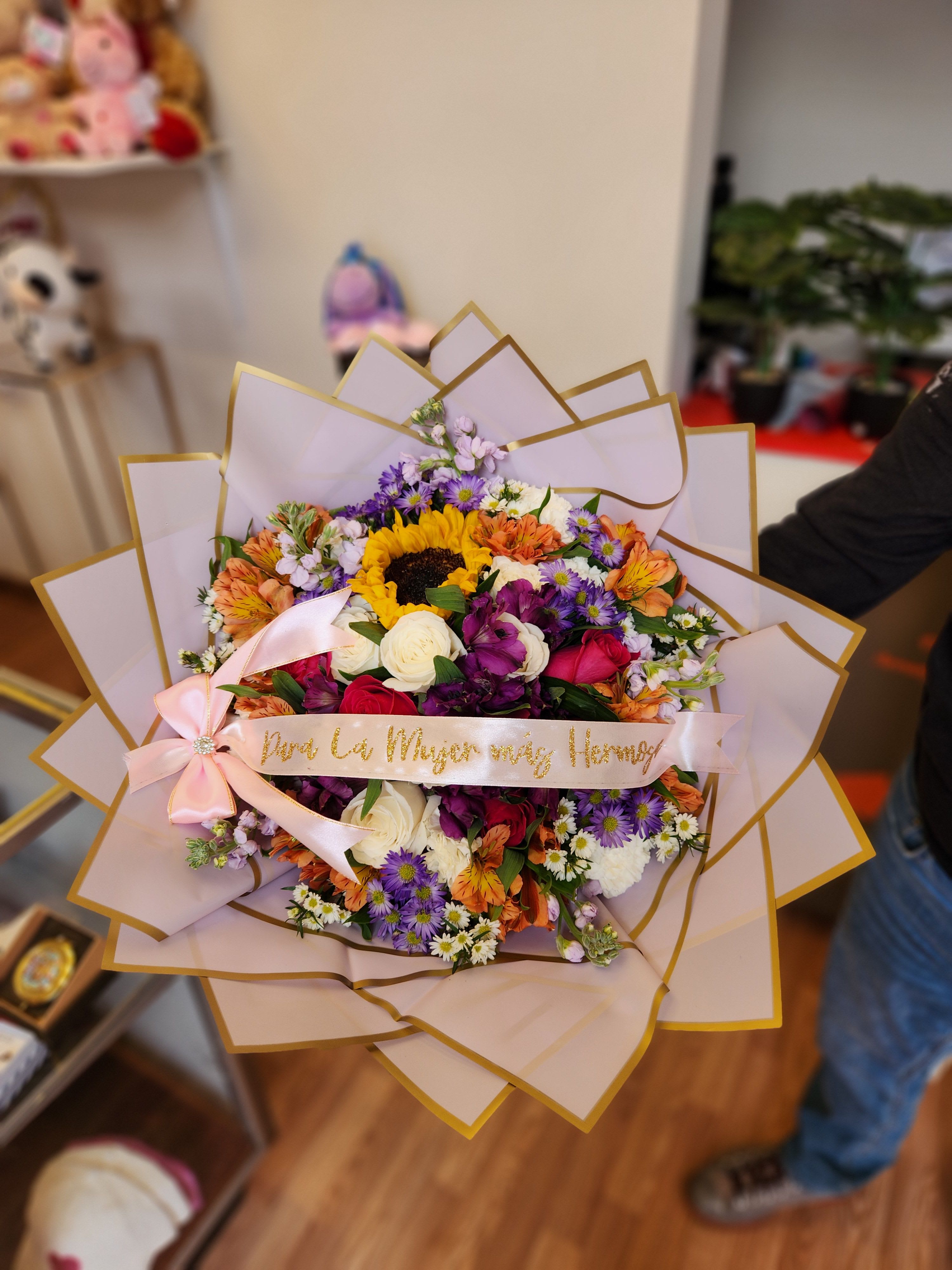 Colorful mixed bouquet with a pink ribbon and gold-edged wrap