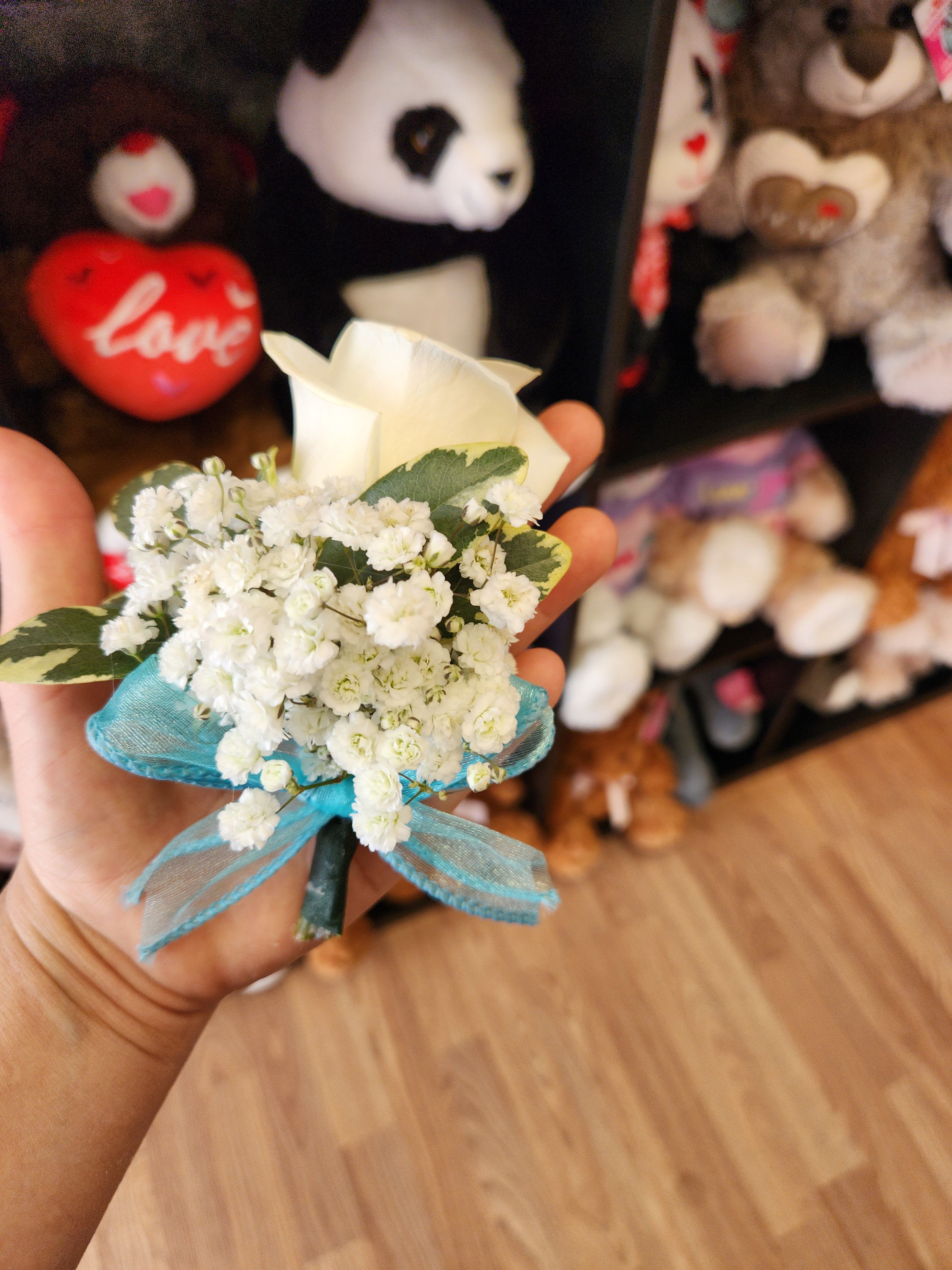 Small white flower boutonniere with blue ribbon