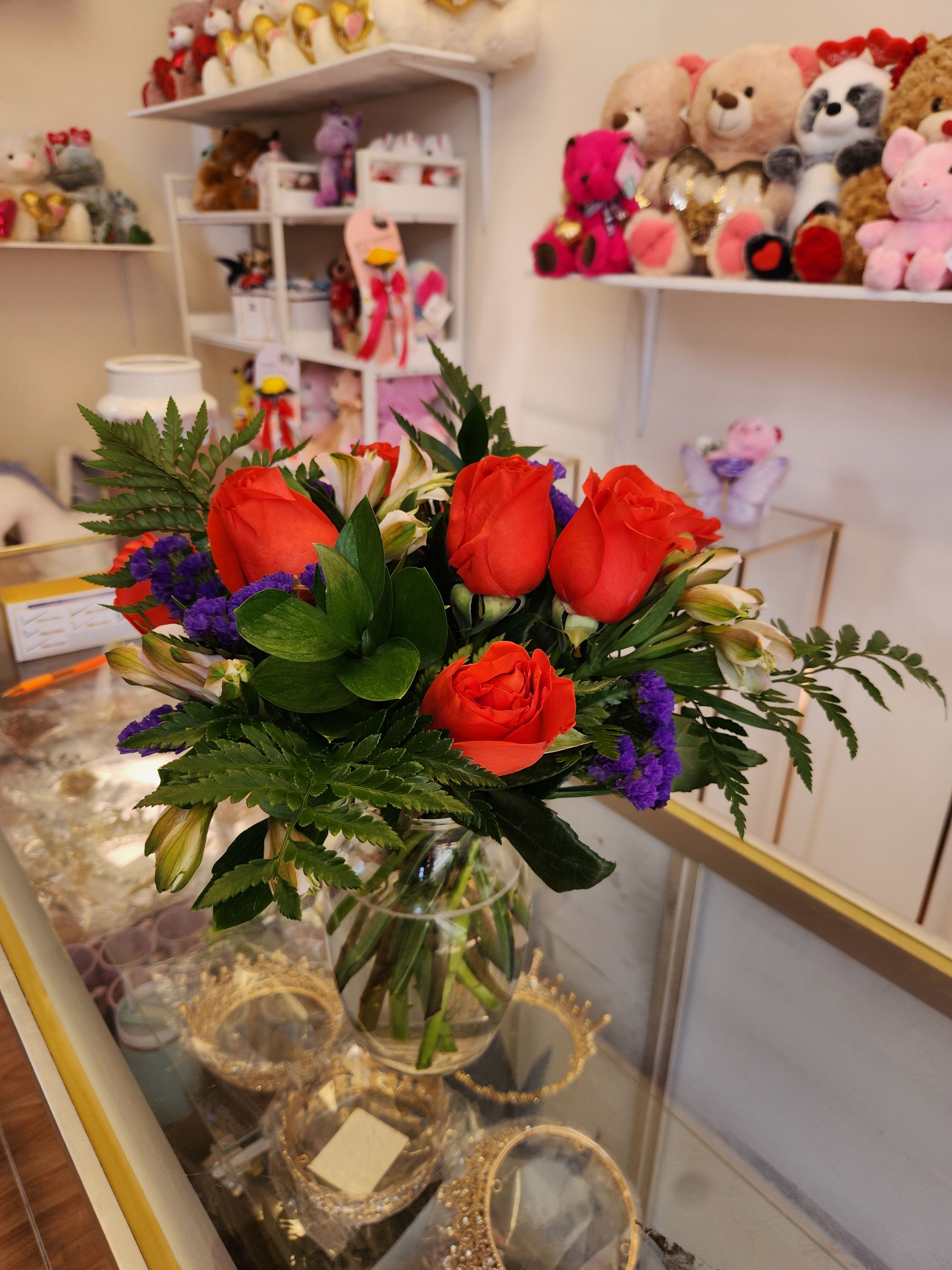 Bouquet of red roses and purple filler flowers in a glass vase