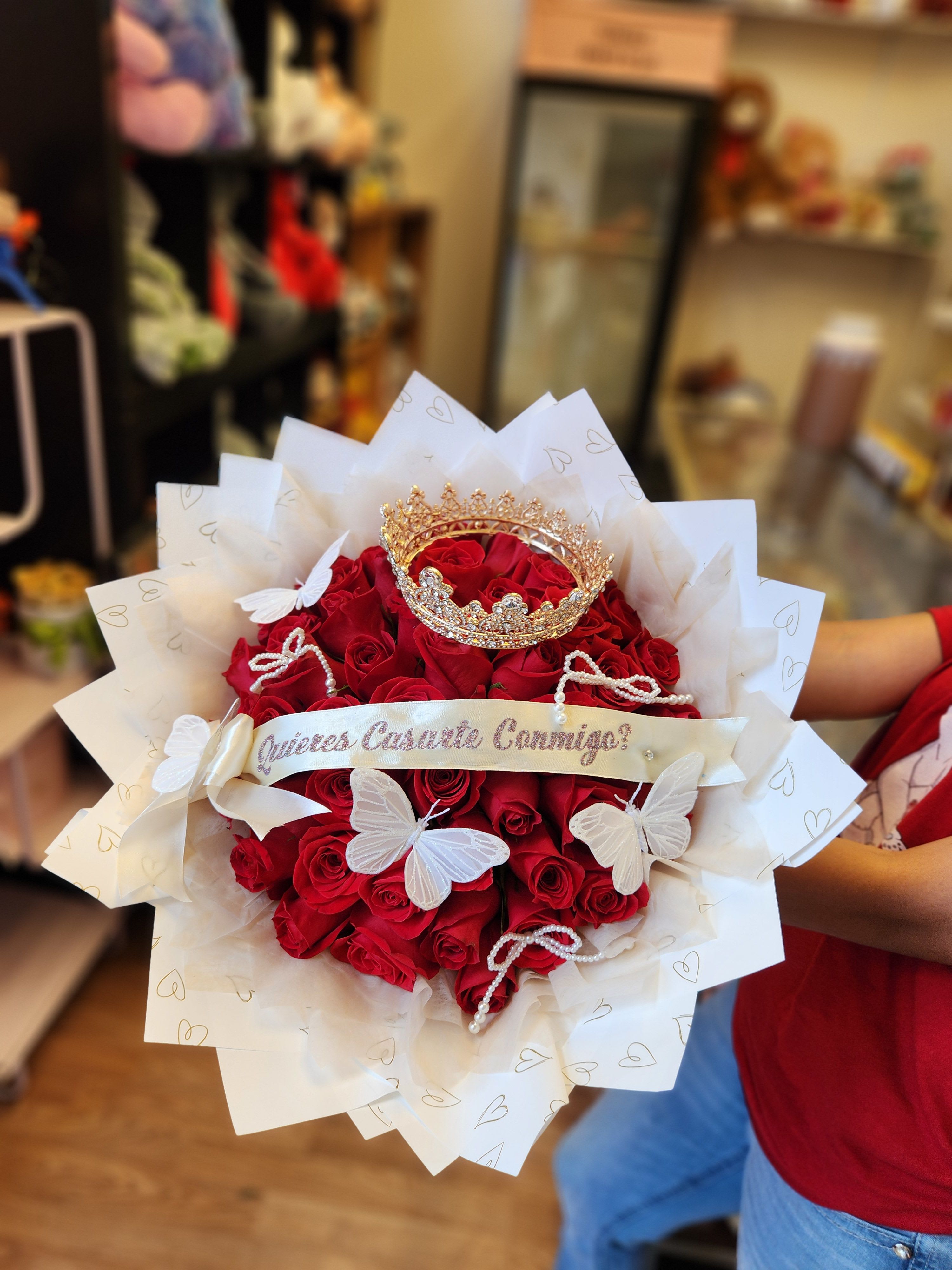 Bouquet of red roses with white butterfly decorations and a gold crown