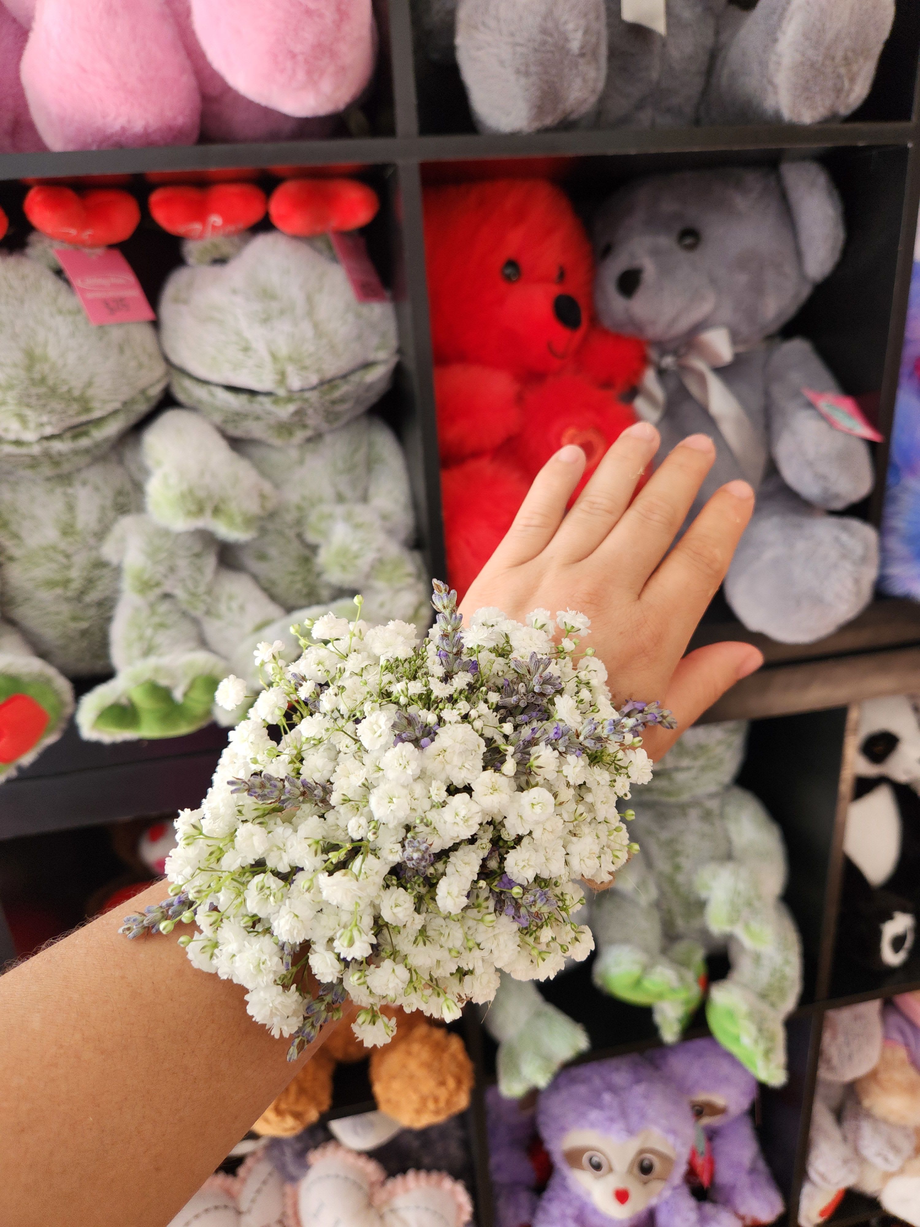 Small white and lavender flower cluster held on a wrist