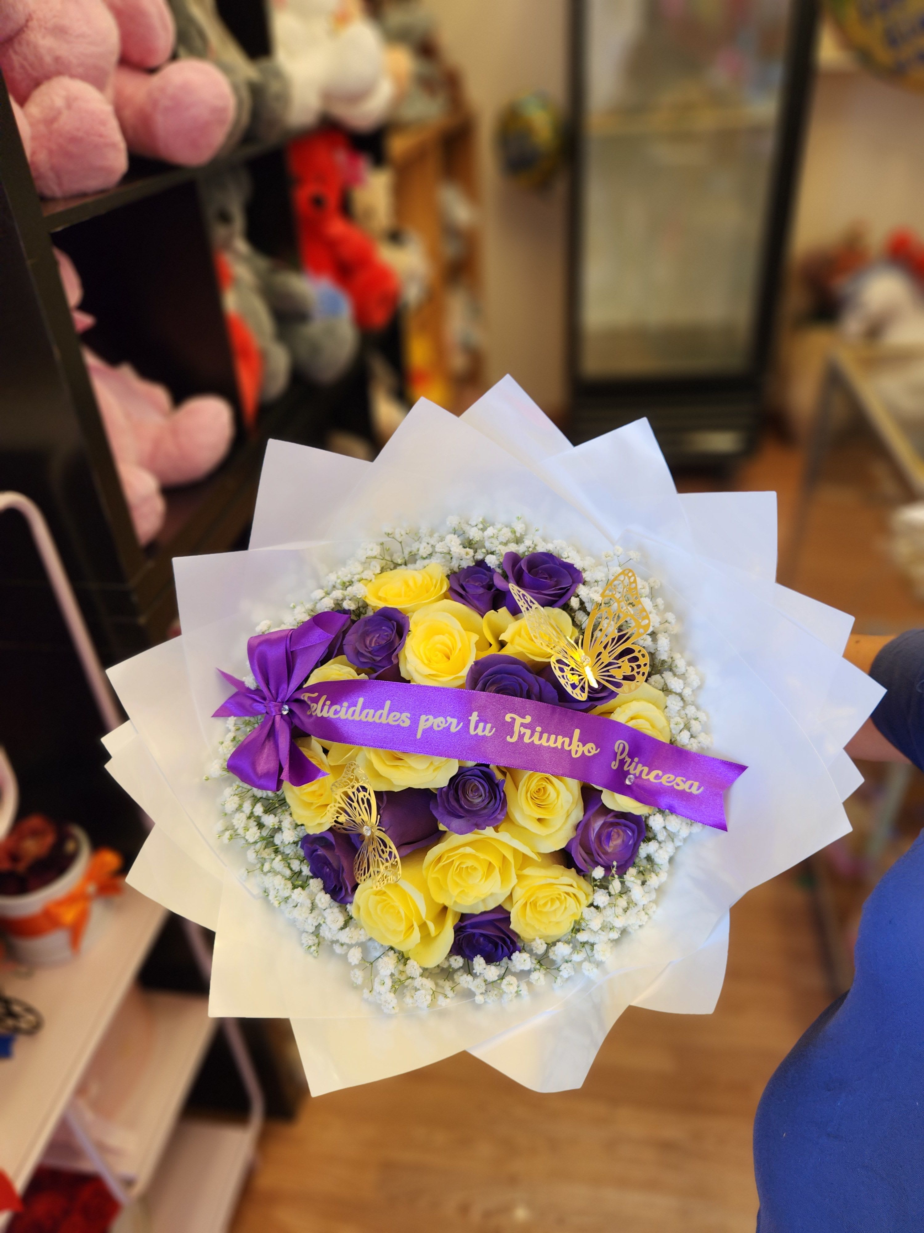 Bouquet of yellow and purple roses with a ribbon and butterfly decorations