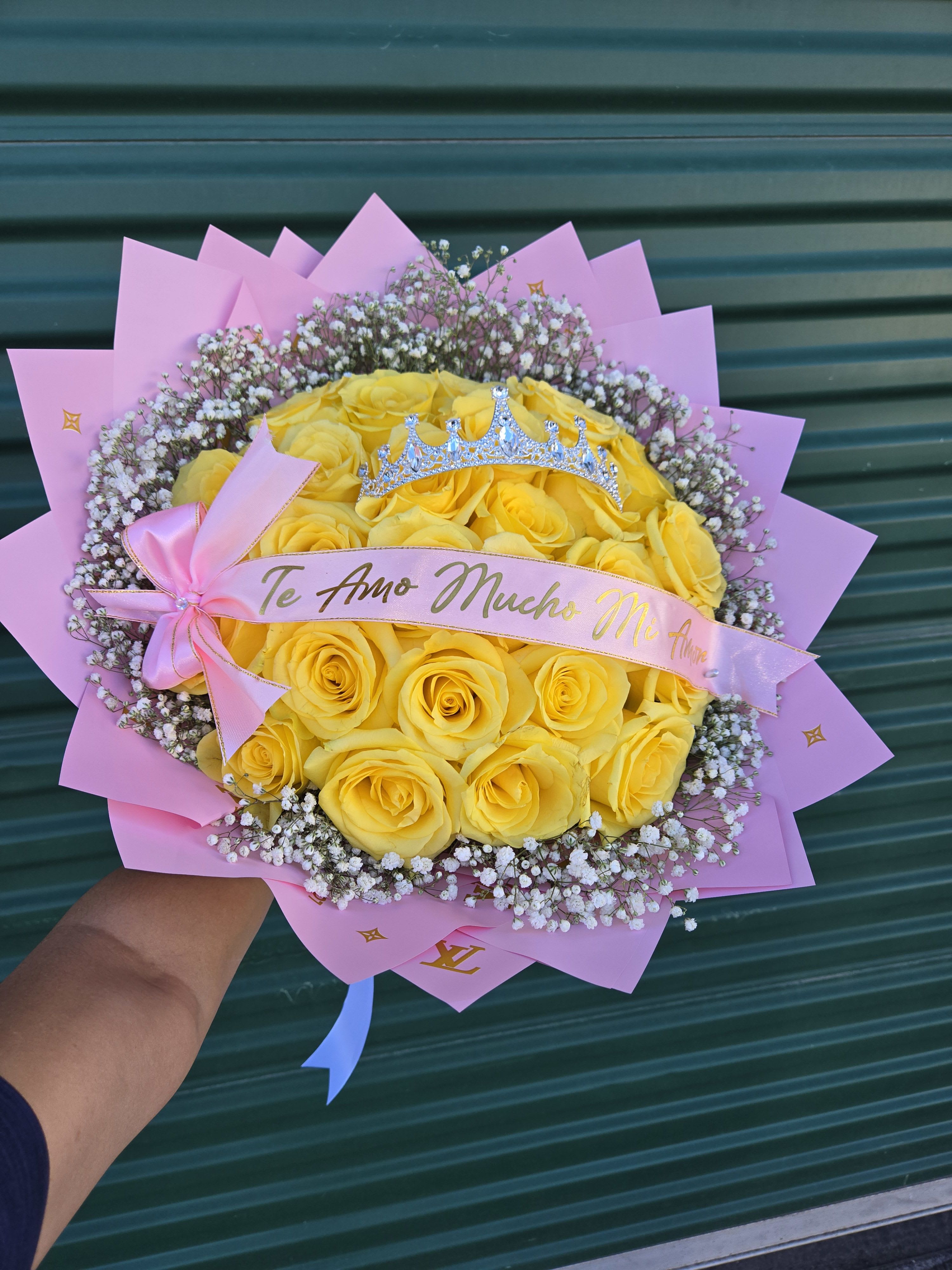 Yellow rose bouquet with pink wrapping and a small crown topper