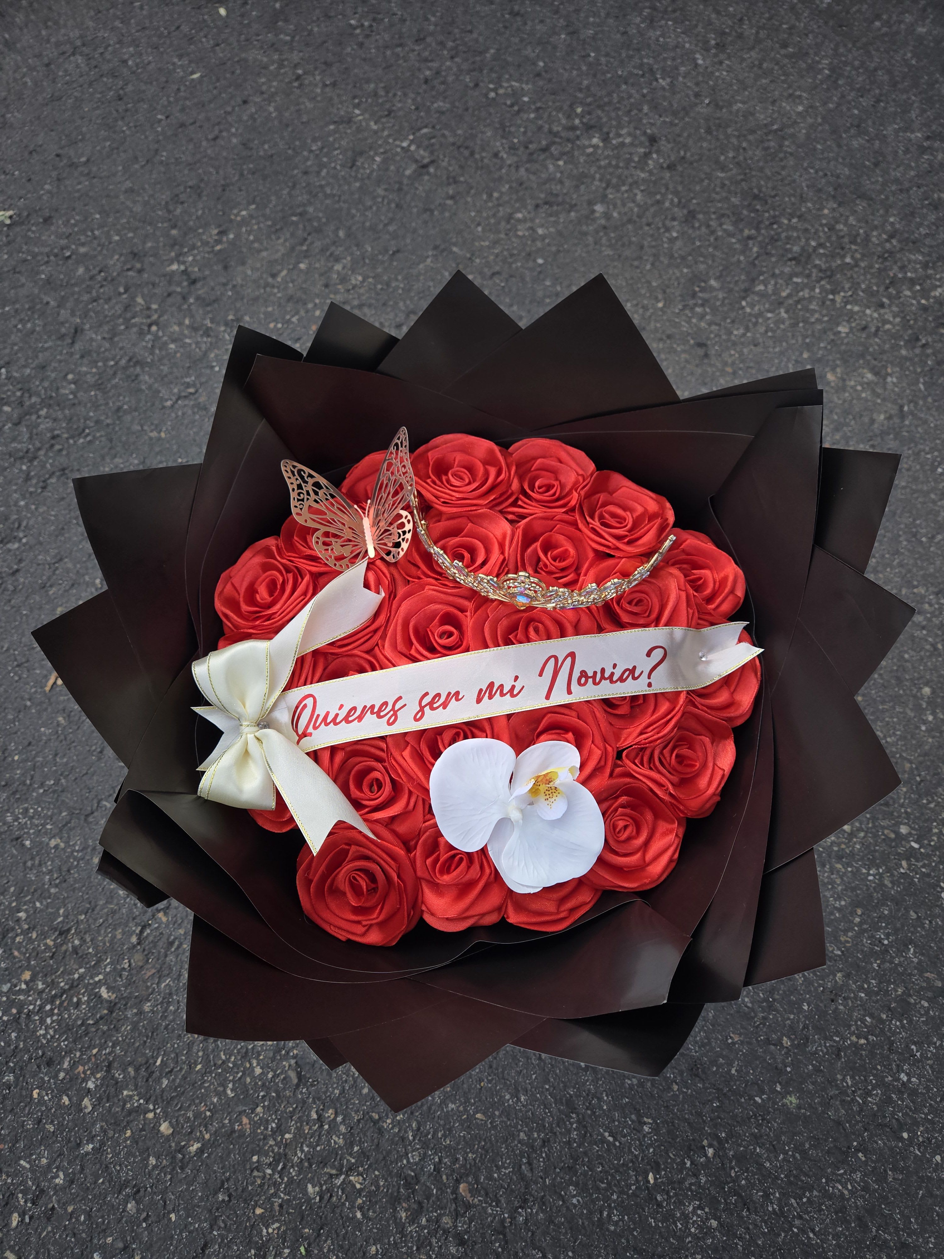 Red rose bouquet with a ribbon and white orchid accent