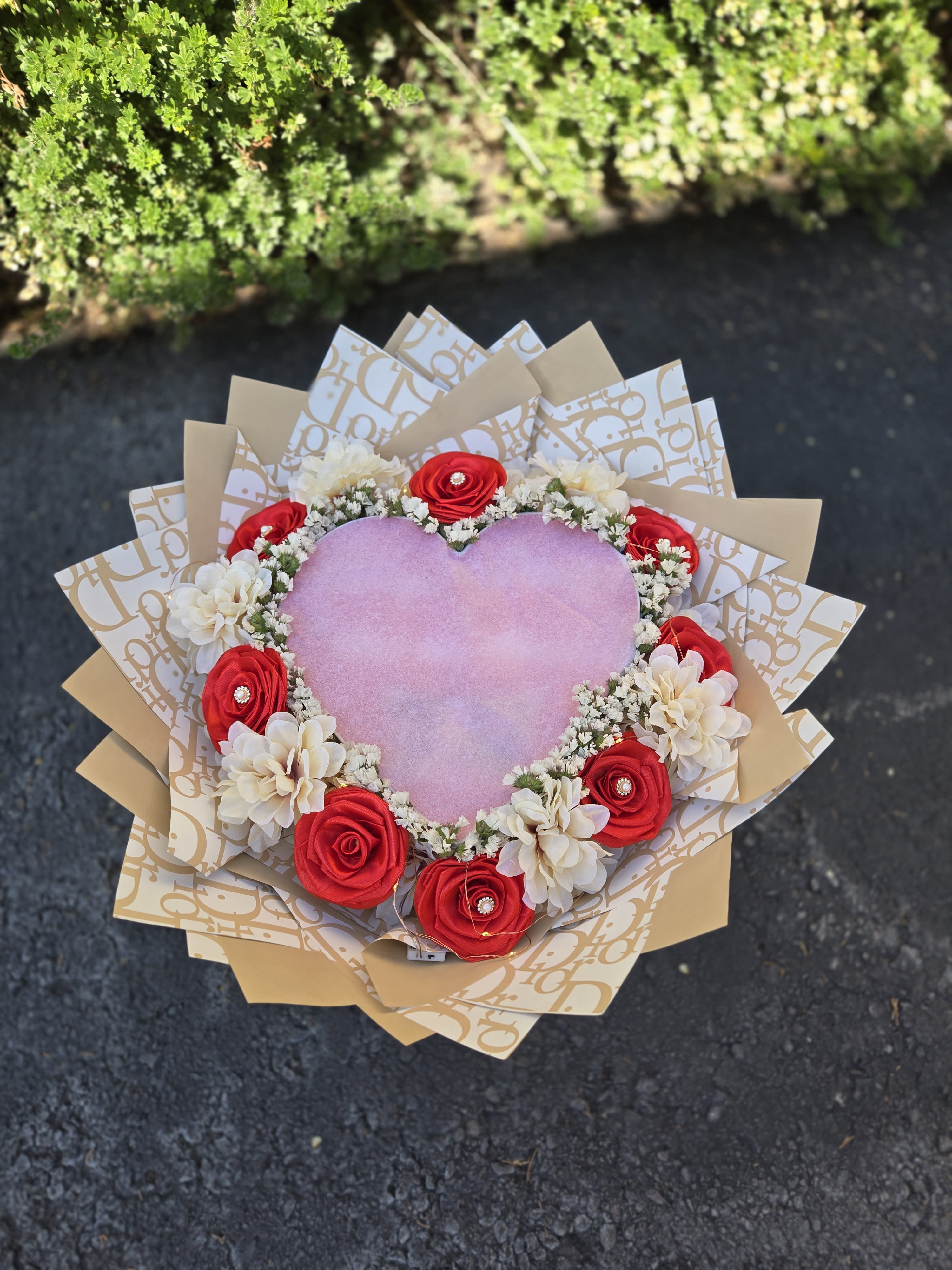 Heart-shaped bouquet with red and white flowers and pink center