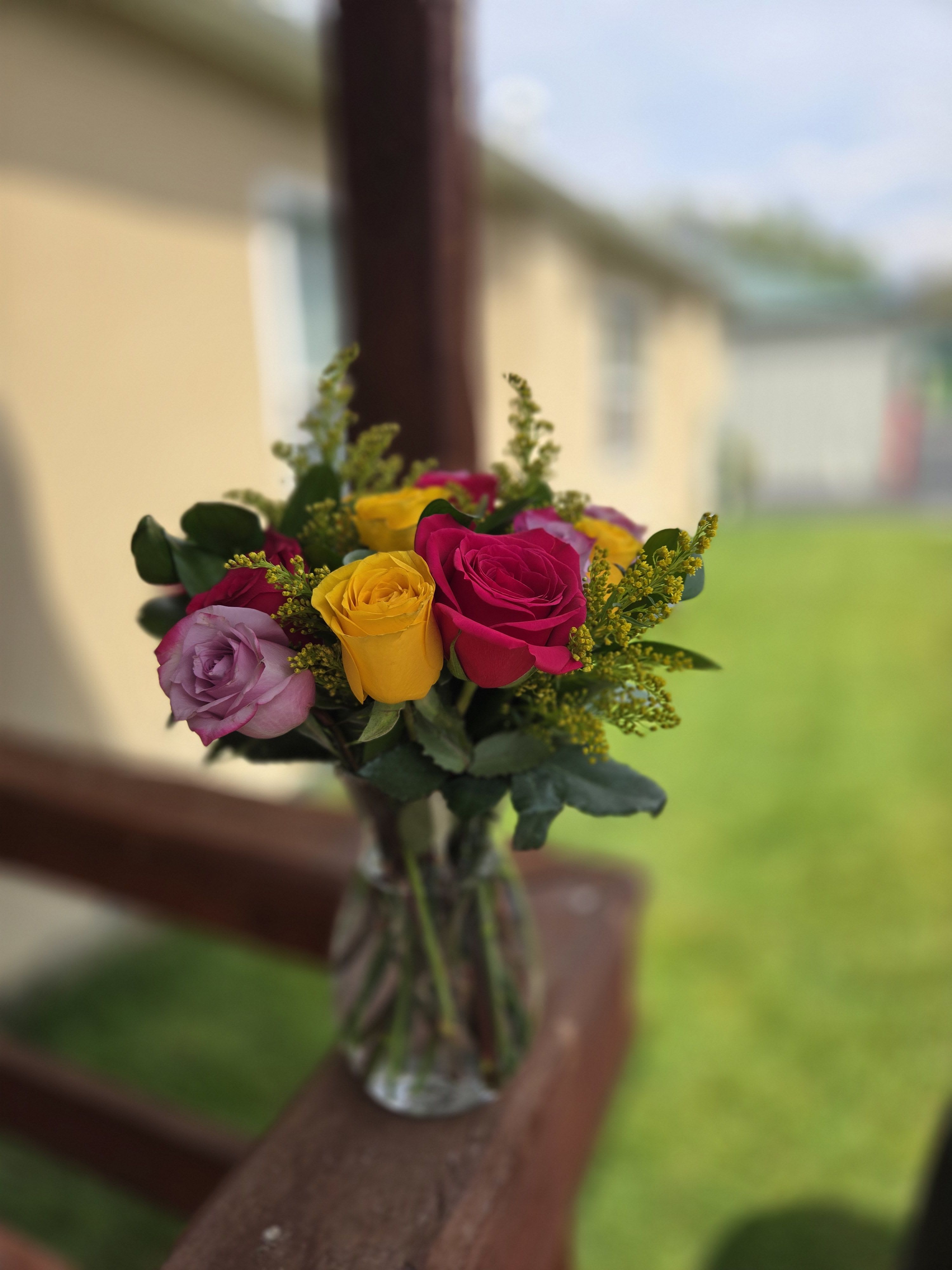 Bouquet of multicolored roses in a clear glass vase