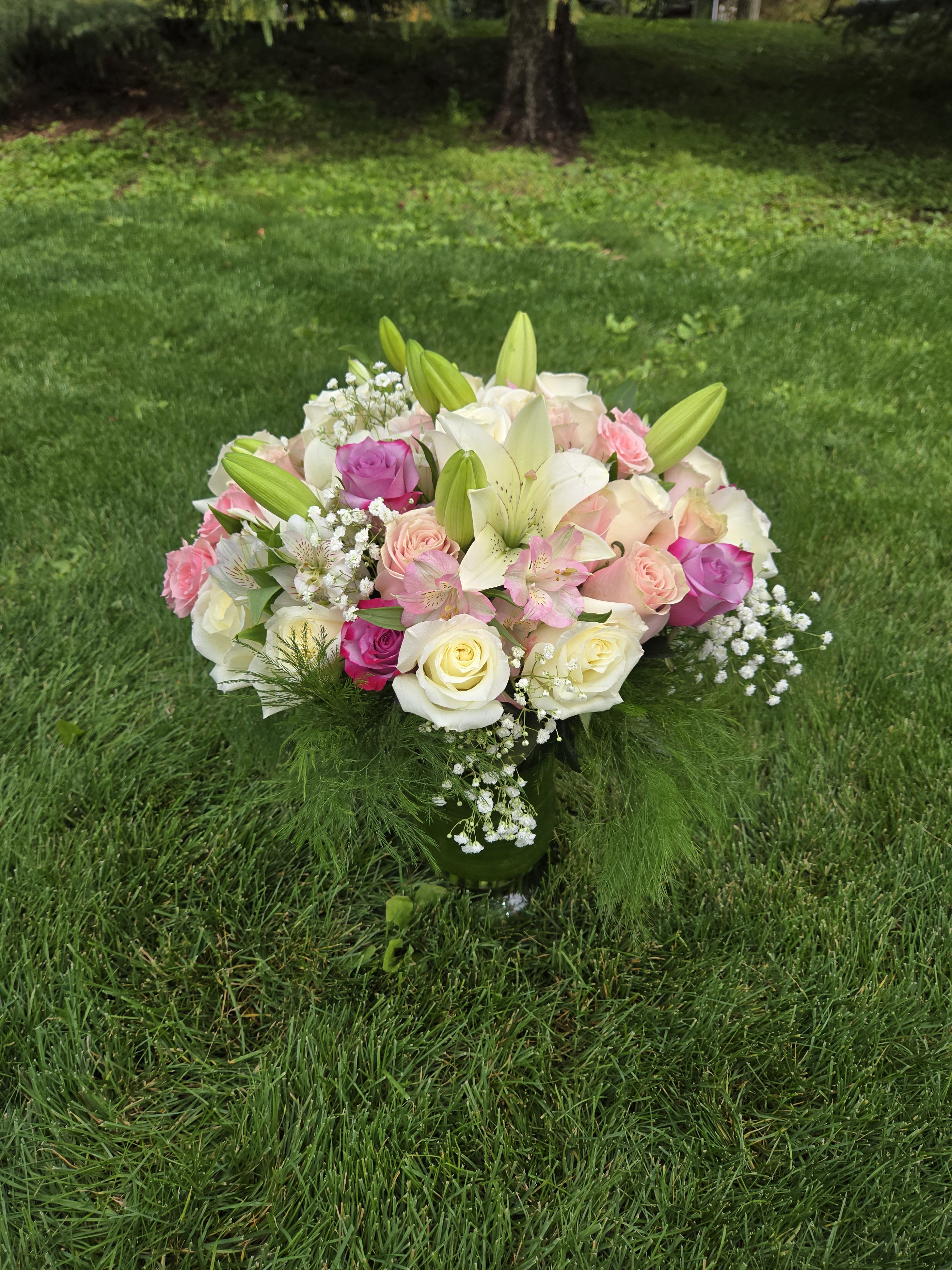 Bouquet of pink and white roses with lilies in a glass vase