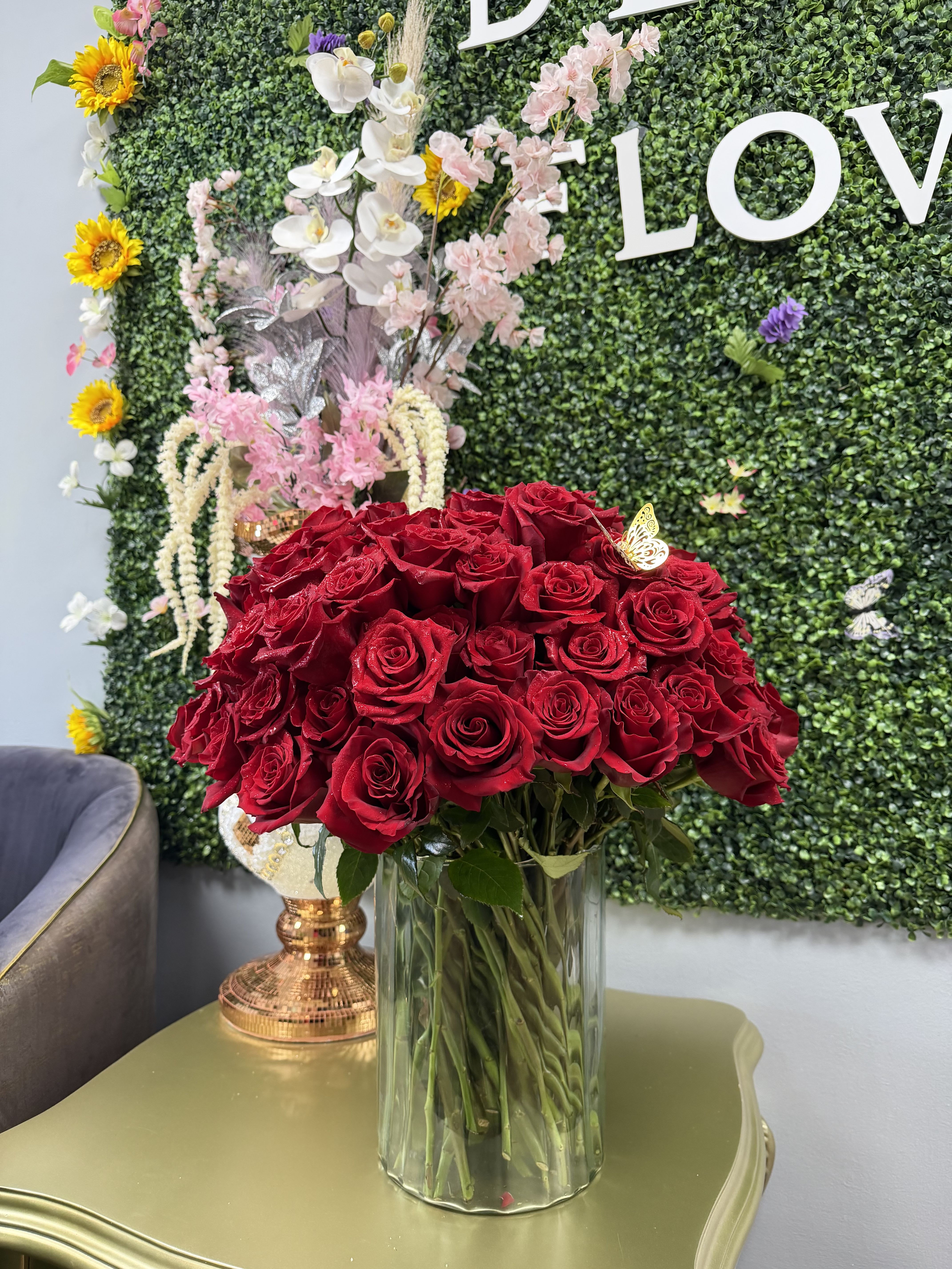 LOVE BOMB - 100 BEAUTIFULL RED ROSES ARRANGED NICELY IN A LARGE CLEAR VASE WITH A CUTE RED RIBBON ADDING A CUTE TOUCH TO IT. IF YOU PREFFER A DIFFERENT COLOR OF ROSE WE CAN ALSO CHANGE IT FOR OUT CUSTOMER.