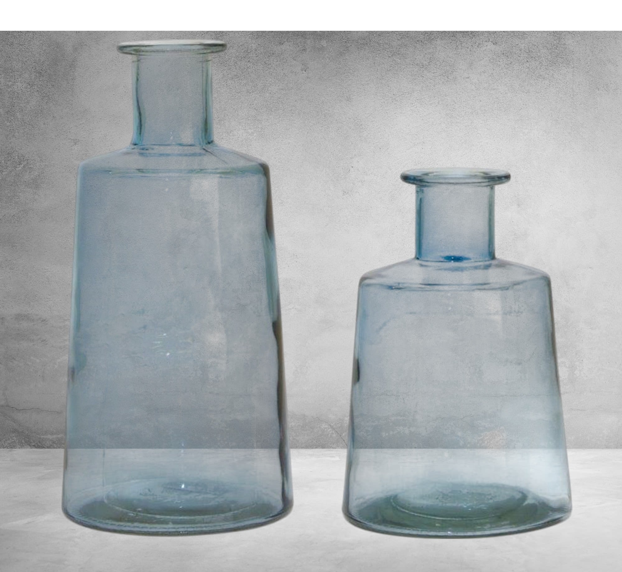 Two blue glass vases on a gray surface