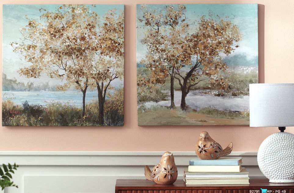 Wall art of trees above a console table with bird figurines and a lamp