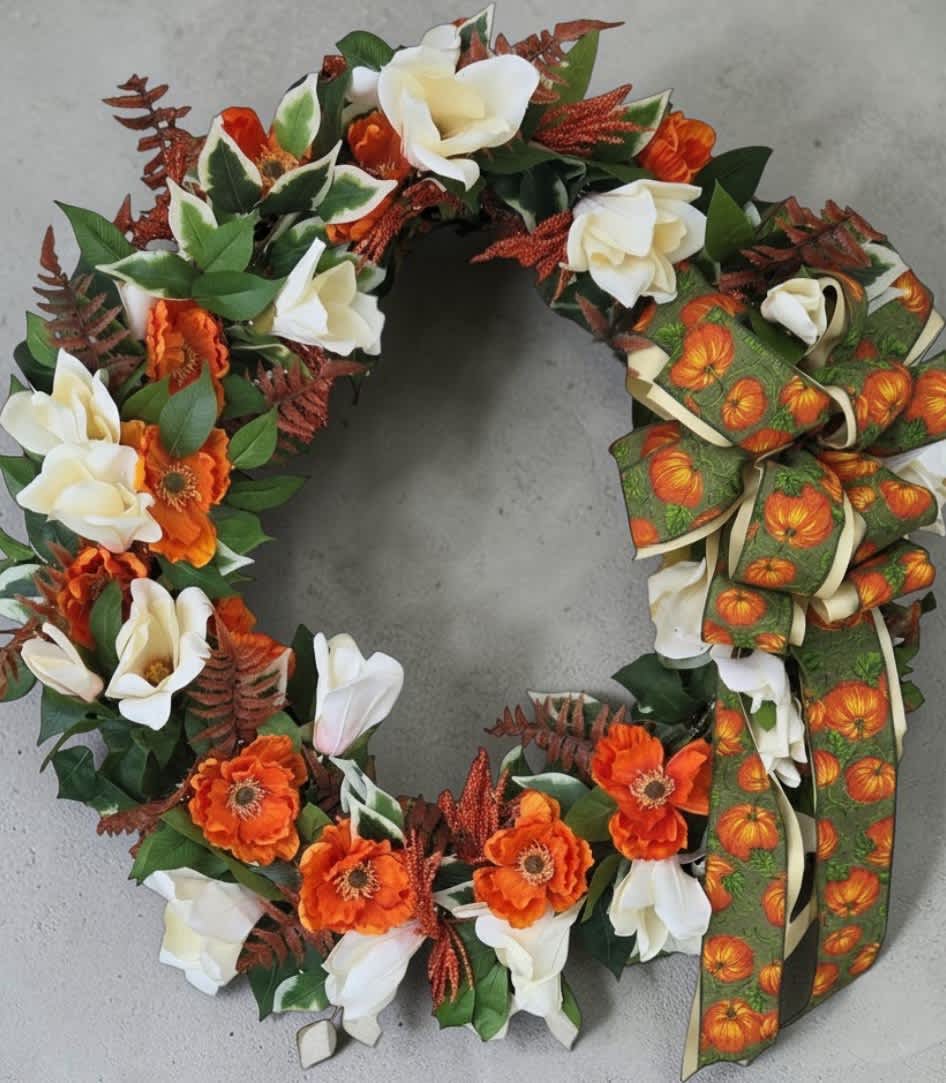 Autumn wreath with white and orange flowers and a pumpkin ribbon bow
