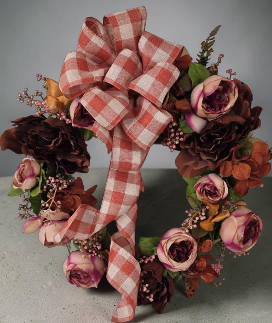 Floral wreath with pink and burgundy roses and a plaid ribbon bow