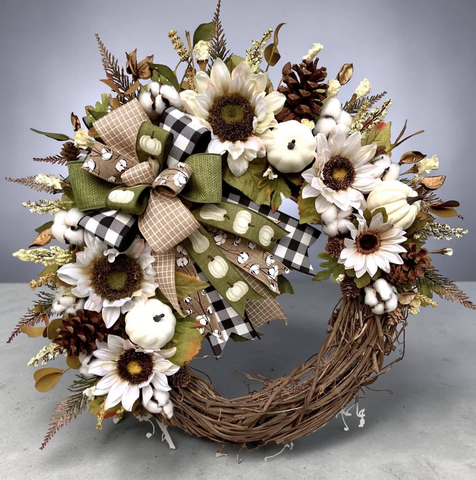 Autumn wreath with sunflowers, cotton bolls, pinecones, and ribbon bows