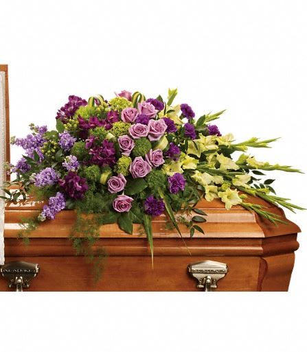  Reflections of Gratitude Casket Spray - Devotion is beautifully expressed with lavender roses, purple alstroemeria and other favorites artistically arranged and placed on top of the casket. The lush arrangement includes green miniature hydrangea, lavender roses, purple alstroemeria, green gladioli, green trick dianthus, purple carnations, lavender stock and green hypericum, accented with assorted greenery. Approximately 47" W x 30" H 