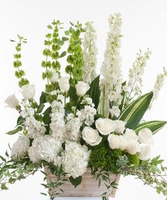 White floral arrangement with tall green and white spikes in a rectangular container