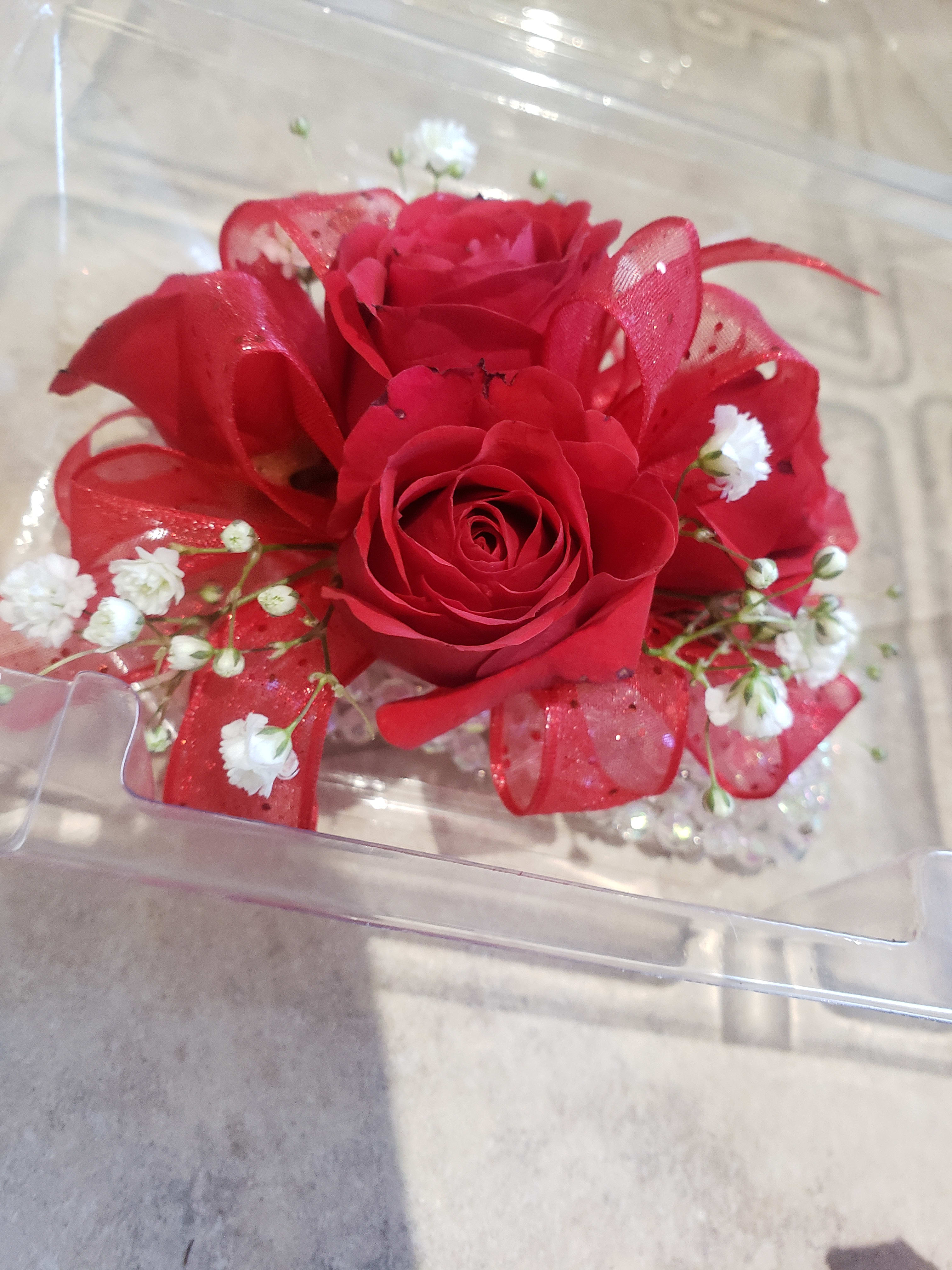Red rose arrangement with white baby's breath in a clear box