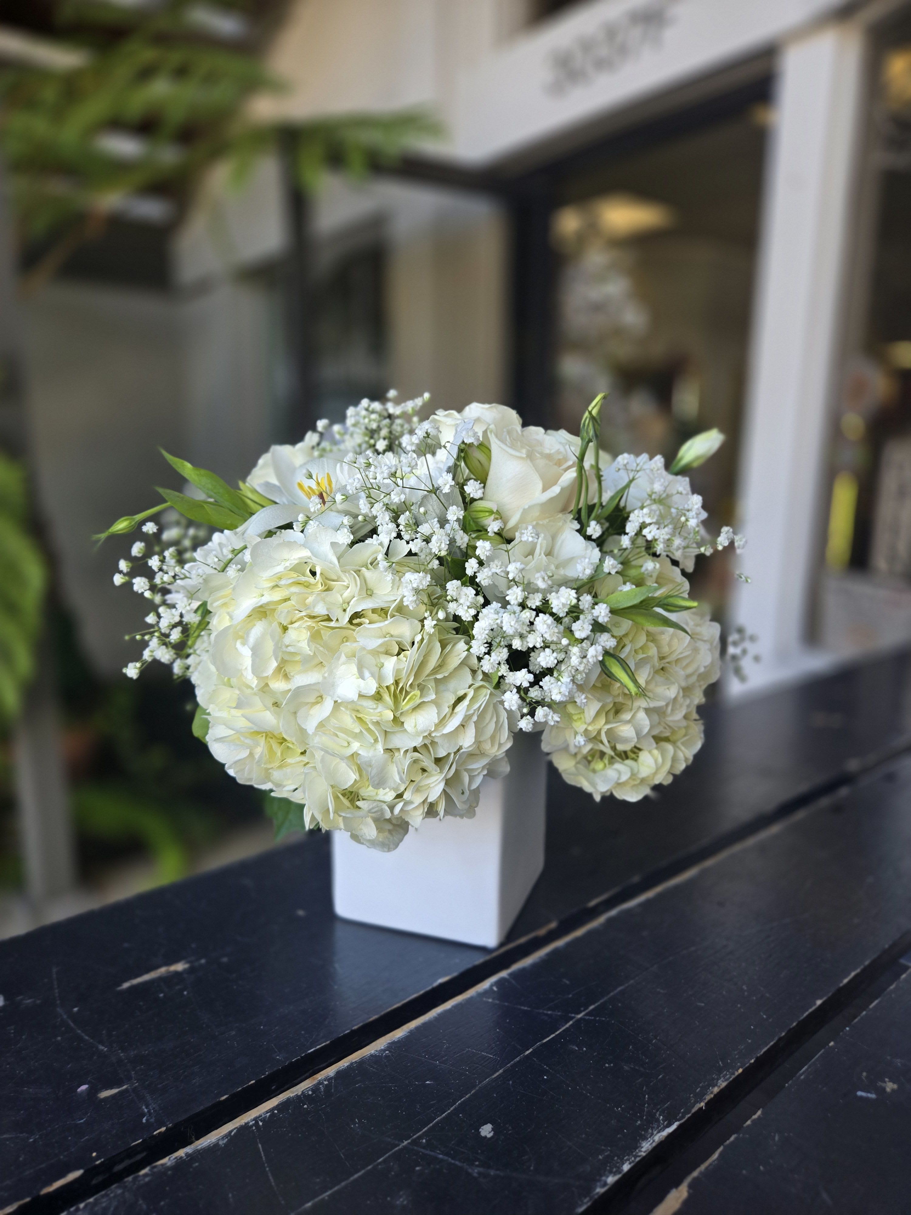 White hydrangea and rose bouquet in a white vase